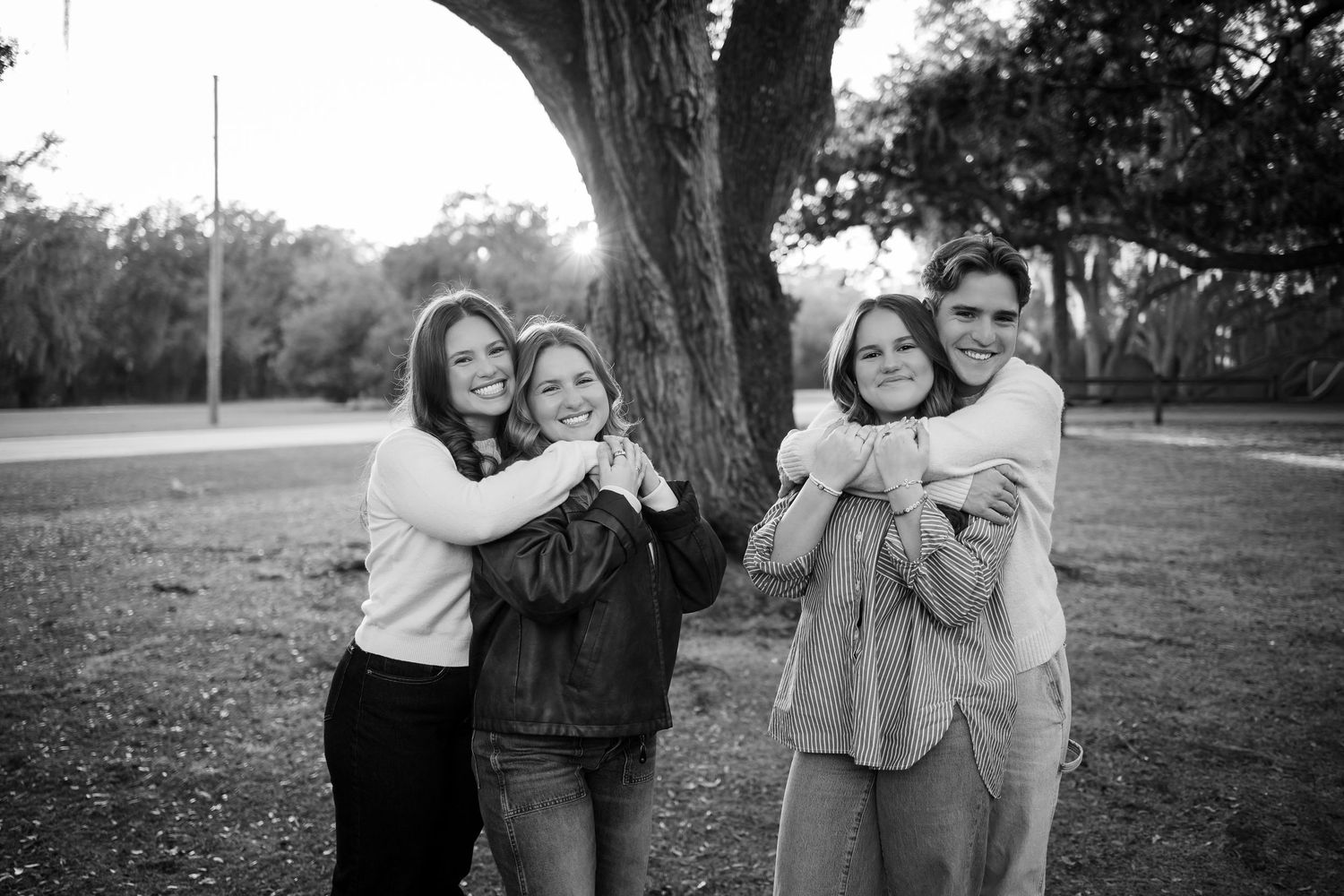 Black and white candid photos of people embracing and laughing together outdoors.