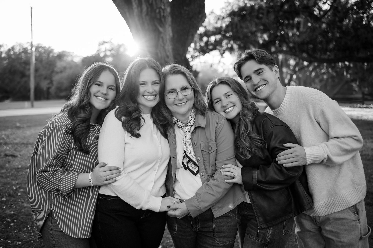 Friends in casual outfits posing together for a candid photo outdoors.