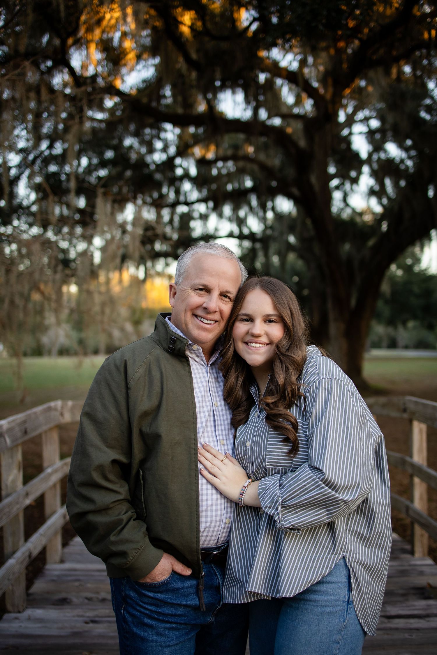 A couple sharing joyful moments together on a wooden bridge during an outdoor photo session.