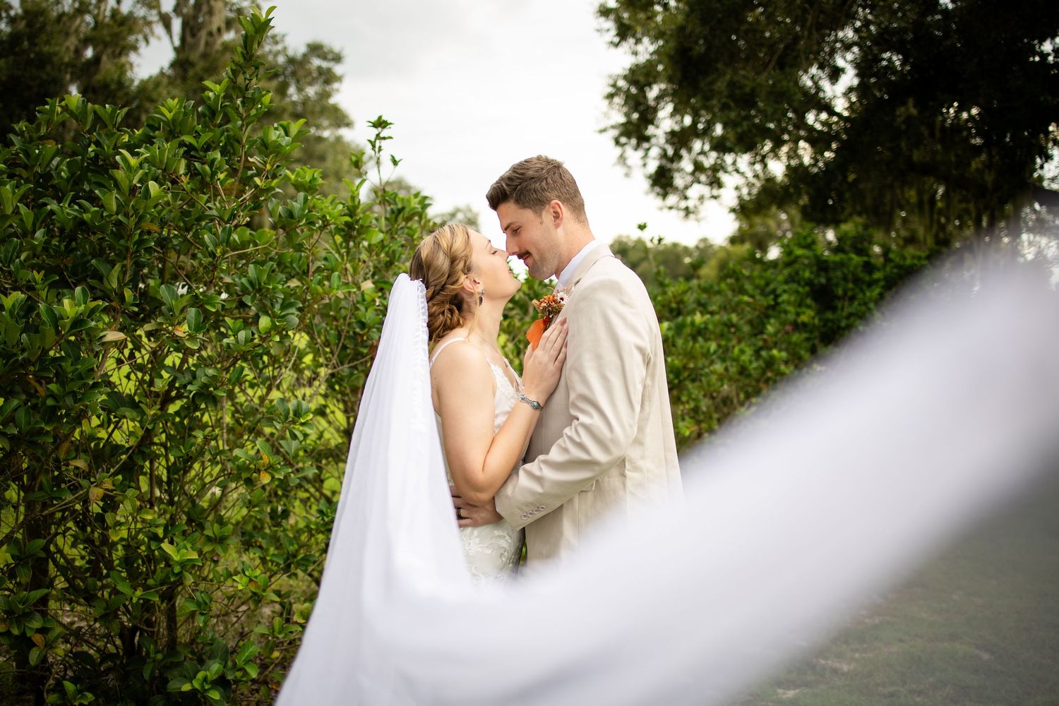 Newlywed couple shares intimate moments in a lush garden setting during their wedding photoshoot.