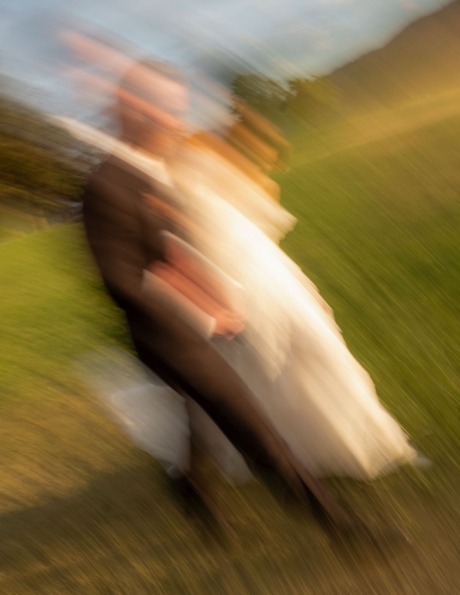 Blurred motion photo of bride and groom walking together outdoors on a sunny day.