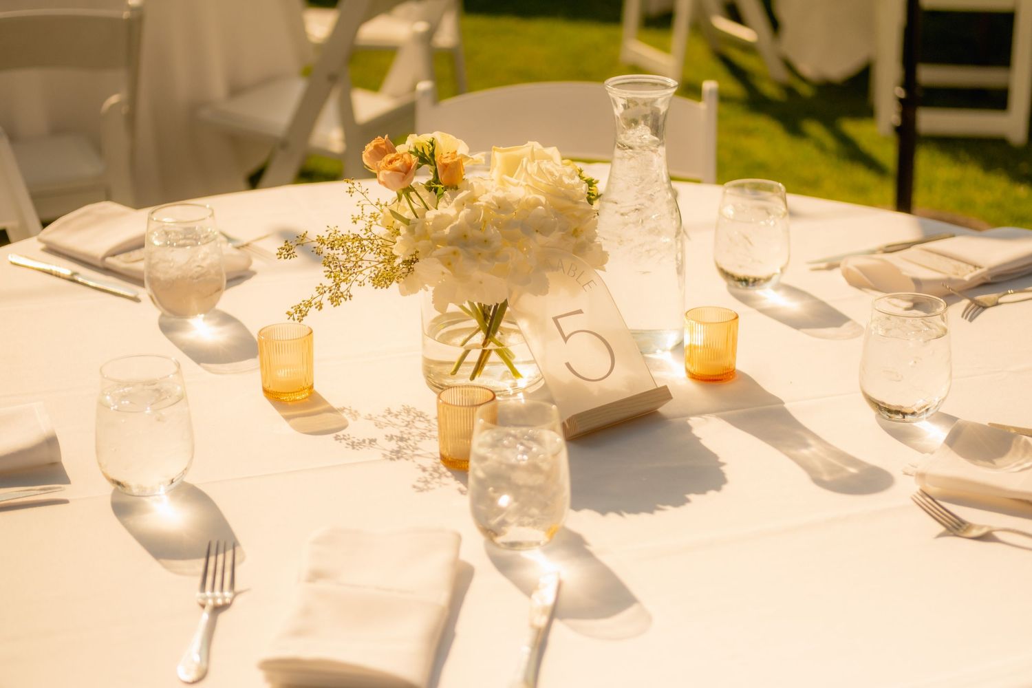 Elegant wedding reception table settings with soft lighting and floral centerpieces.