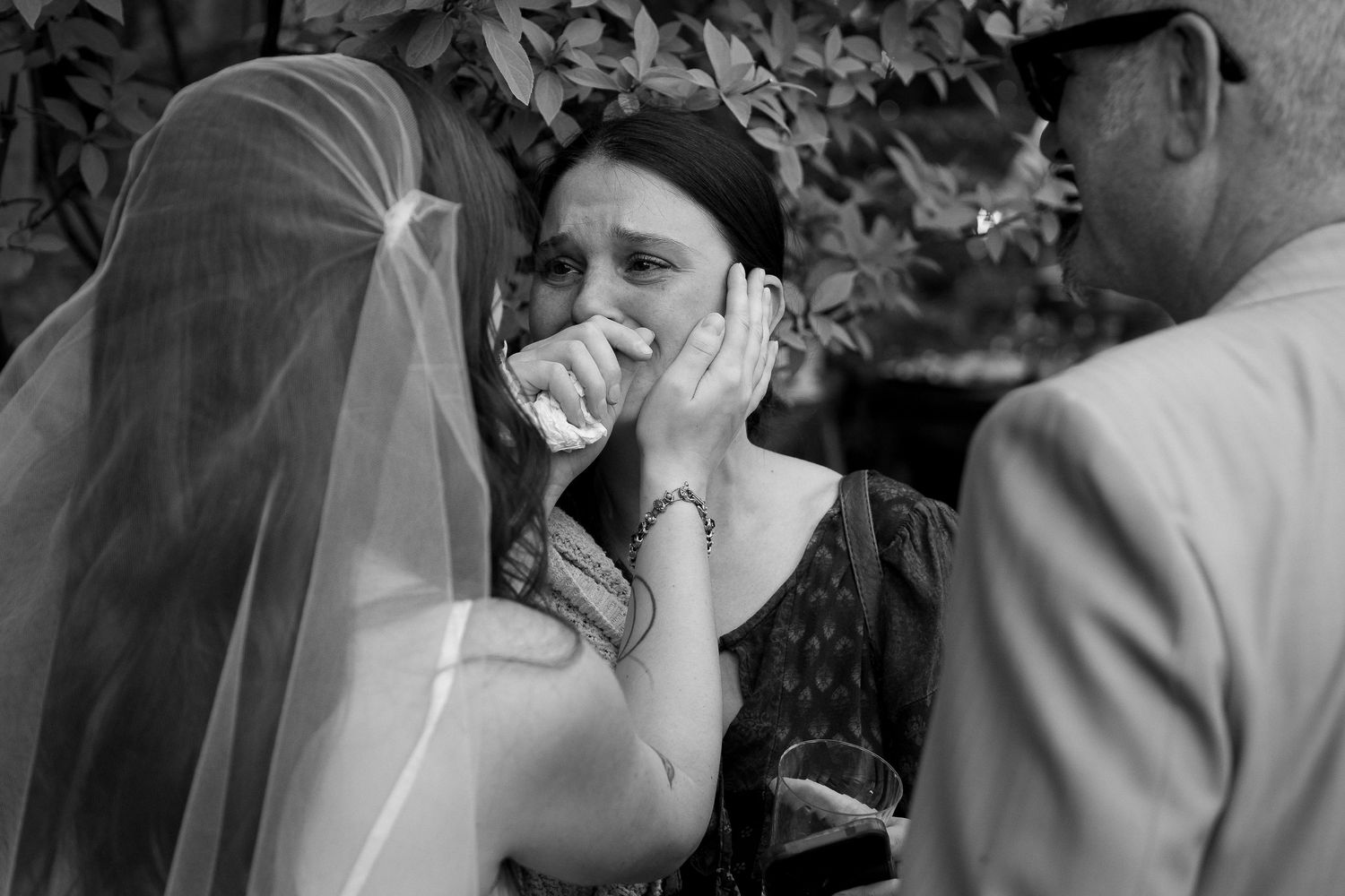 Black and white emotional moments captured during an outdoor wedding celebration.
