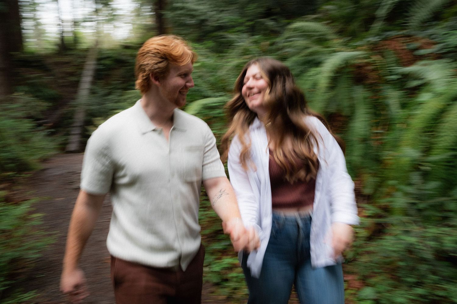 Motion-blurred photograph of people walking through lush forest path.
