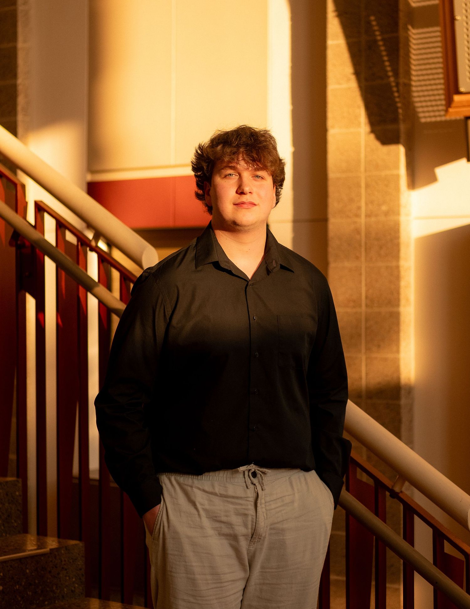 Warm sunset light illuminates a stairwell with dramatic shadows and orange glow.