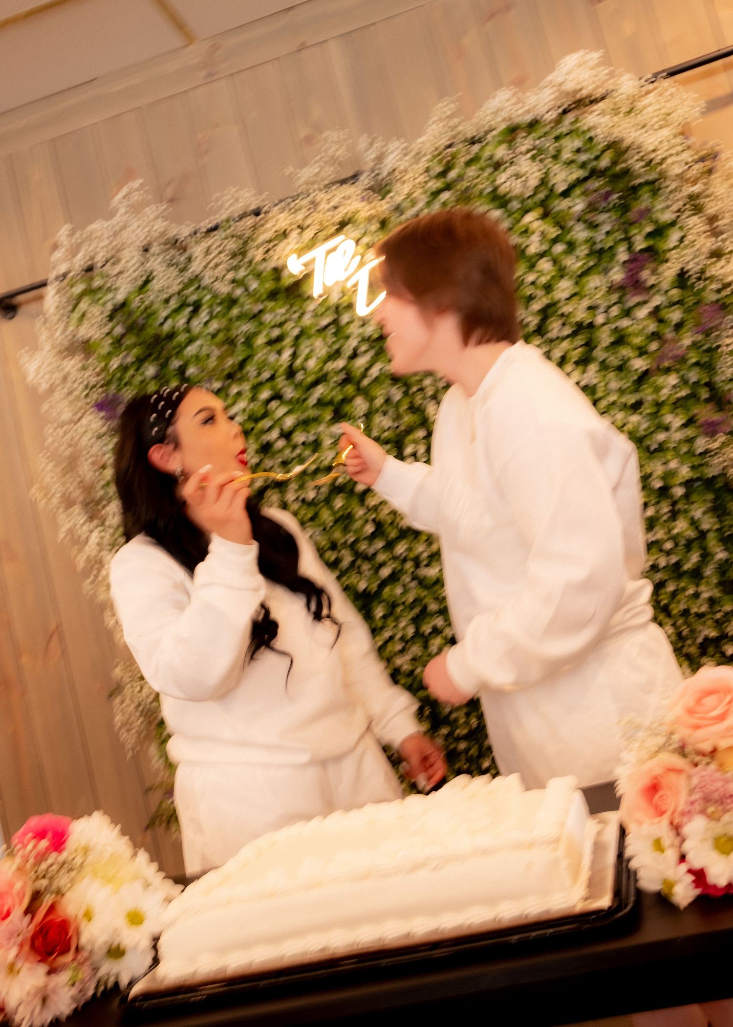 Romantic scene with couple sharing a sweet moment with flowers and greenery in the background.