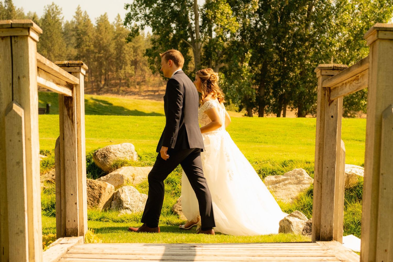 A romantic bridge portrait of newlyweds against a sunny green landscape background.
