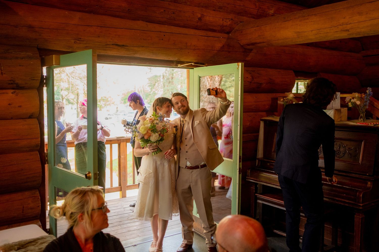 Rustic log cabin wedding venue interior with natural lighting and wooden beams.