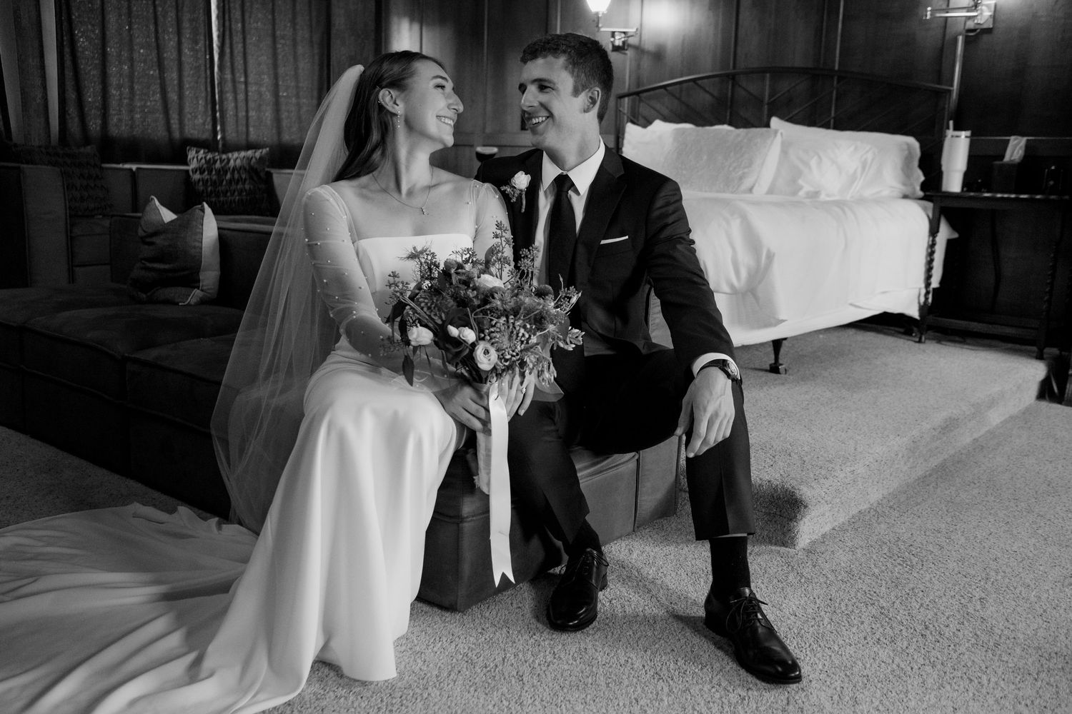 Black and white candid wedding reception scene with formal attire.