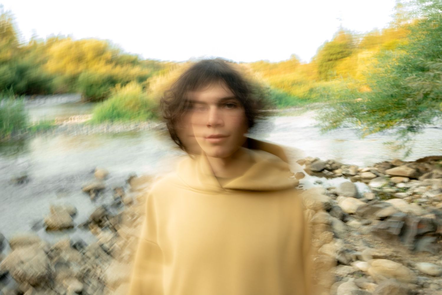 Abstract motion blur photography in warm tones against a rocky natural background.