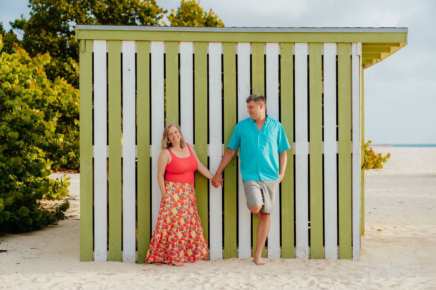 A sequence of photos showing people posing by a white wooden fence on a beach.