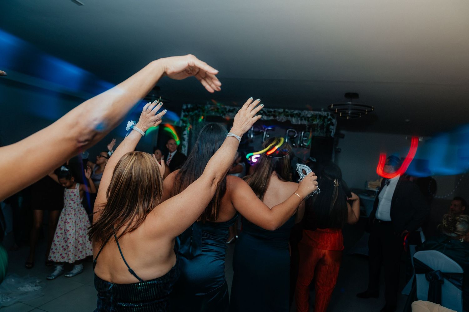Celebration on a dance floor with people dancing under dramatic blue lighting effects.