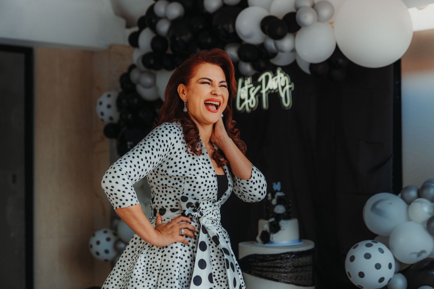 Party celebration with black and white balloon decorations and festive lighting.