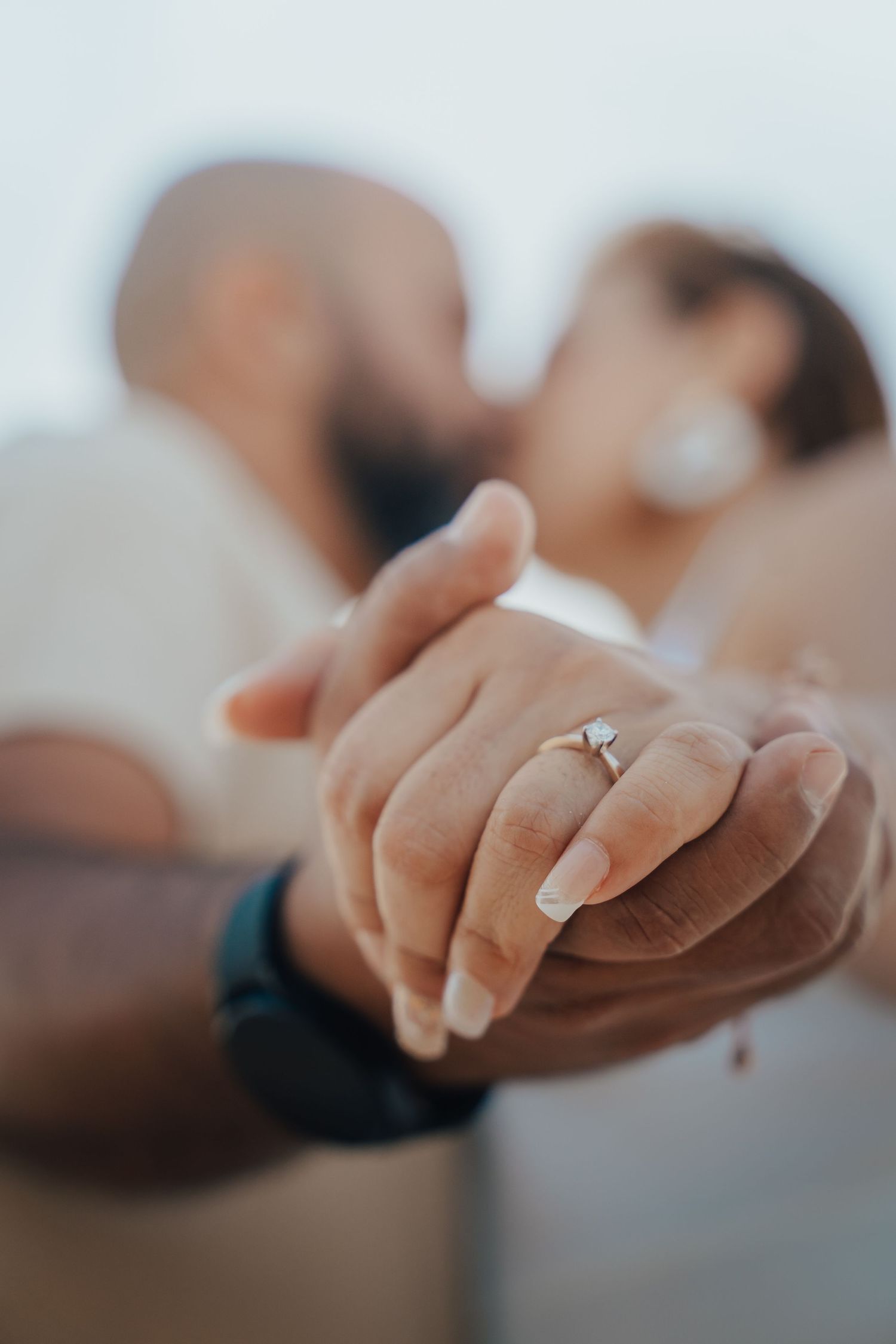 Close-up of hands reaching towards each other in soft focus.