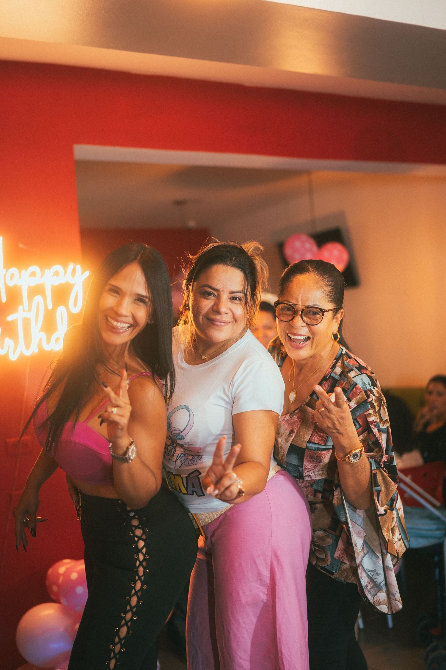 Group celebrating in a room with neon signage and warm lighting.