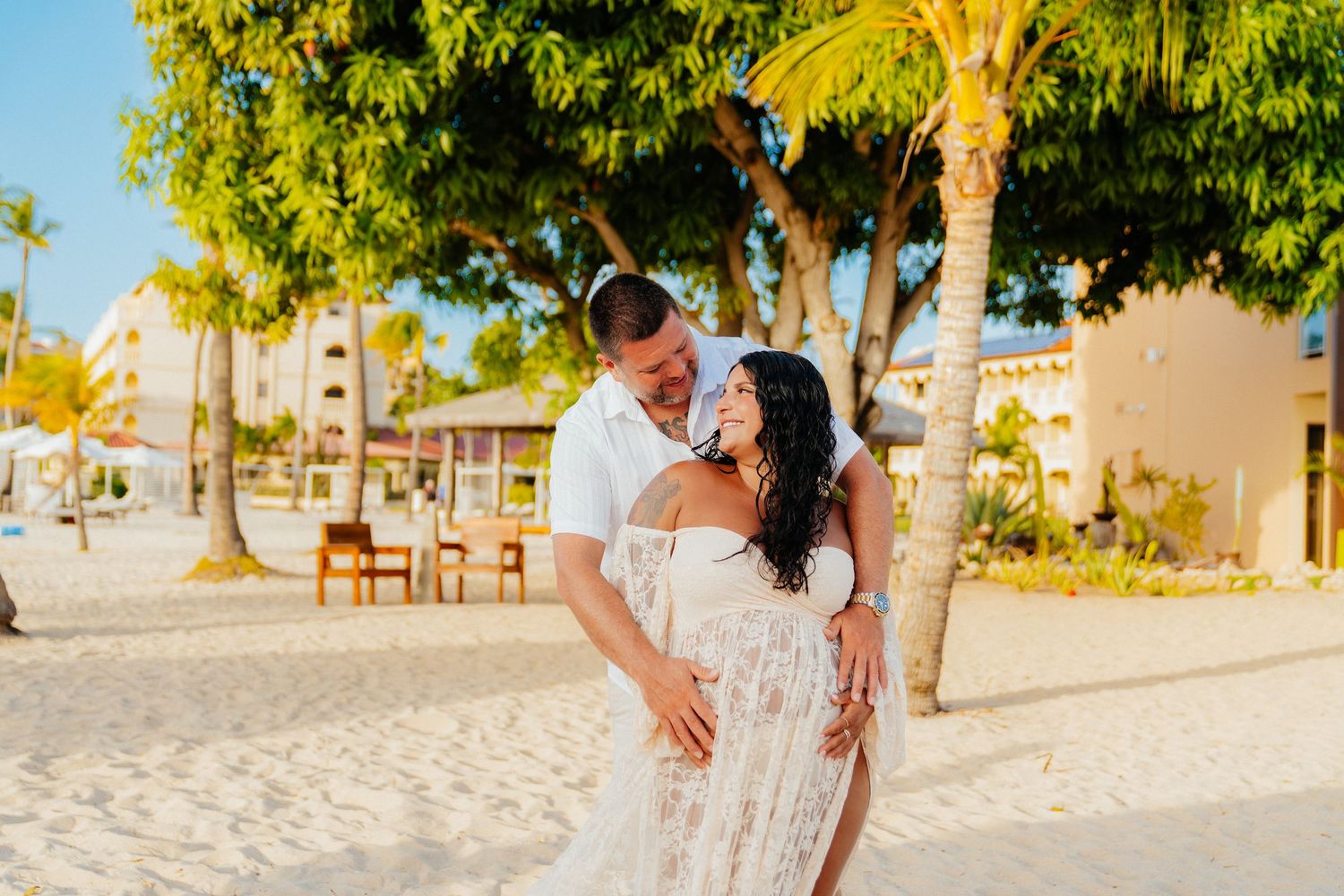 A joyful dance pose on a tropical beach with palm trees in the background.