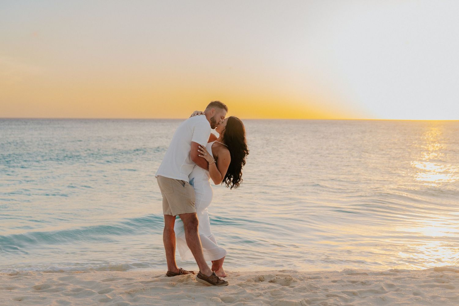 A romantic beach proposal captured during golden hour with ocean views.