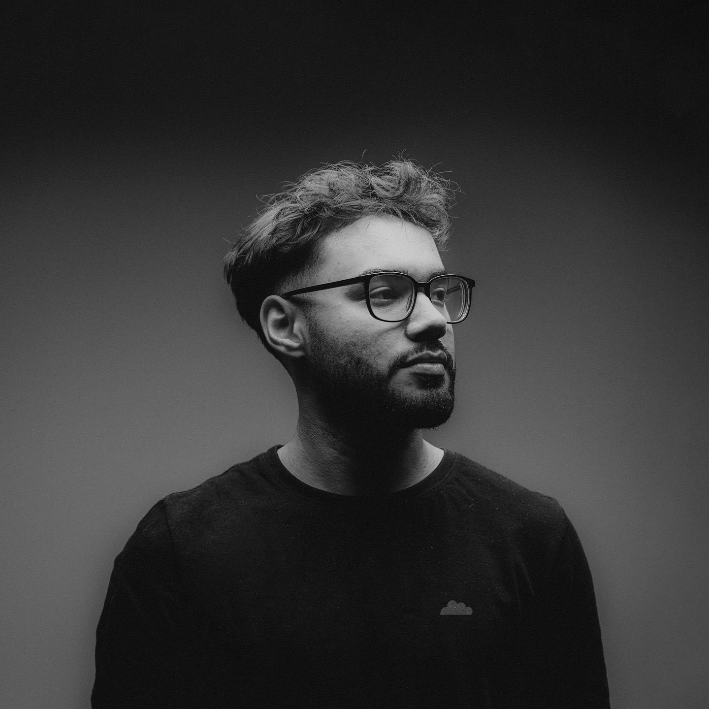Dramatic black and white portrait series showing different angles of a man with glasses.