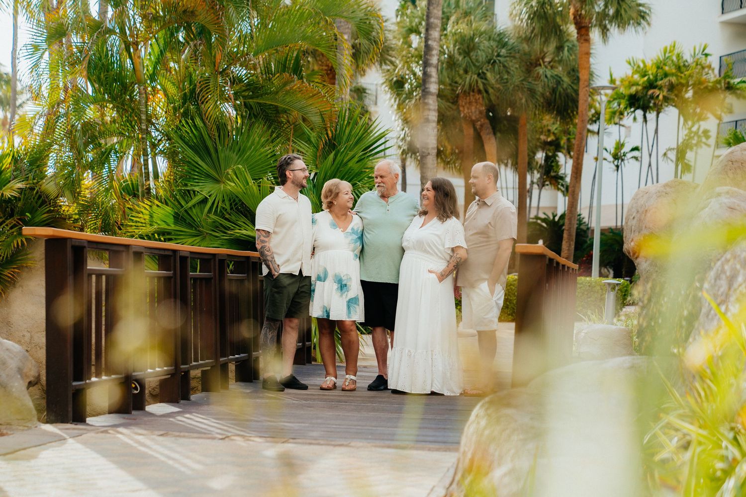 Tropical garden walkway with palm trees and lush greenery at a beachside resort.