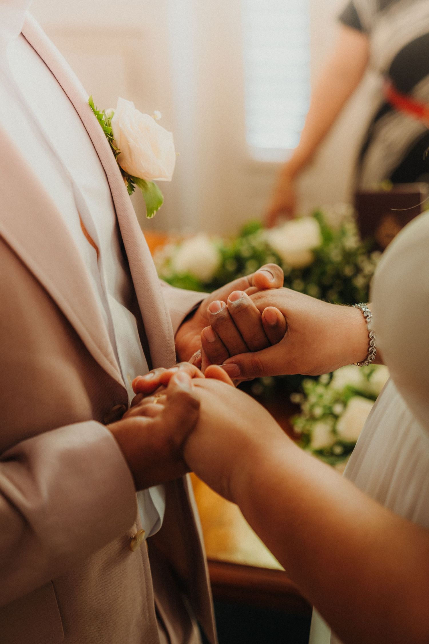 Close-up of hands exchanging rings during wedding ceremony.