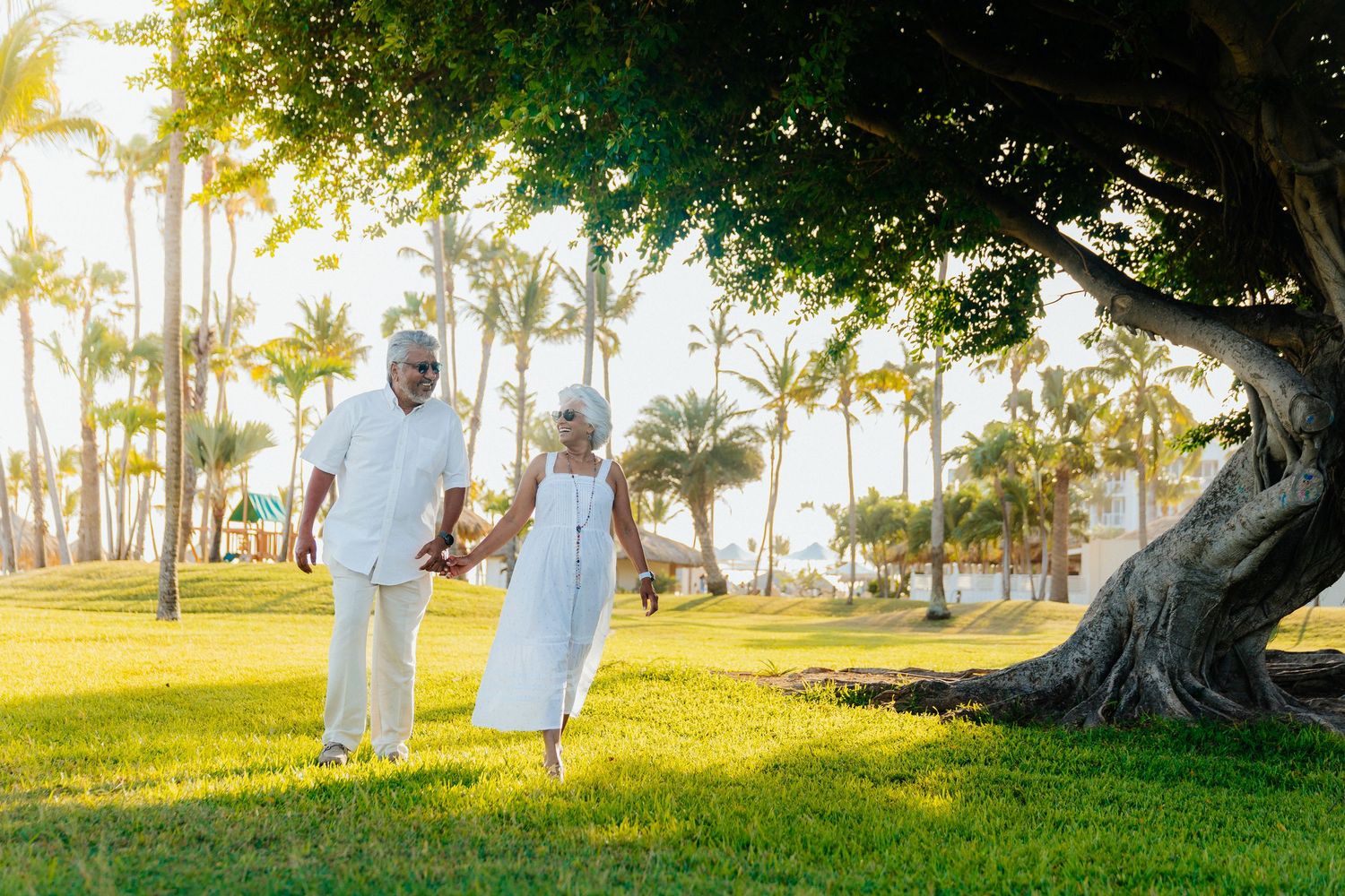 A series of casual outdoor portraits taken under large tropical trees at sunset.