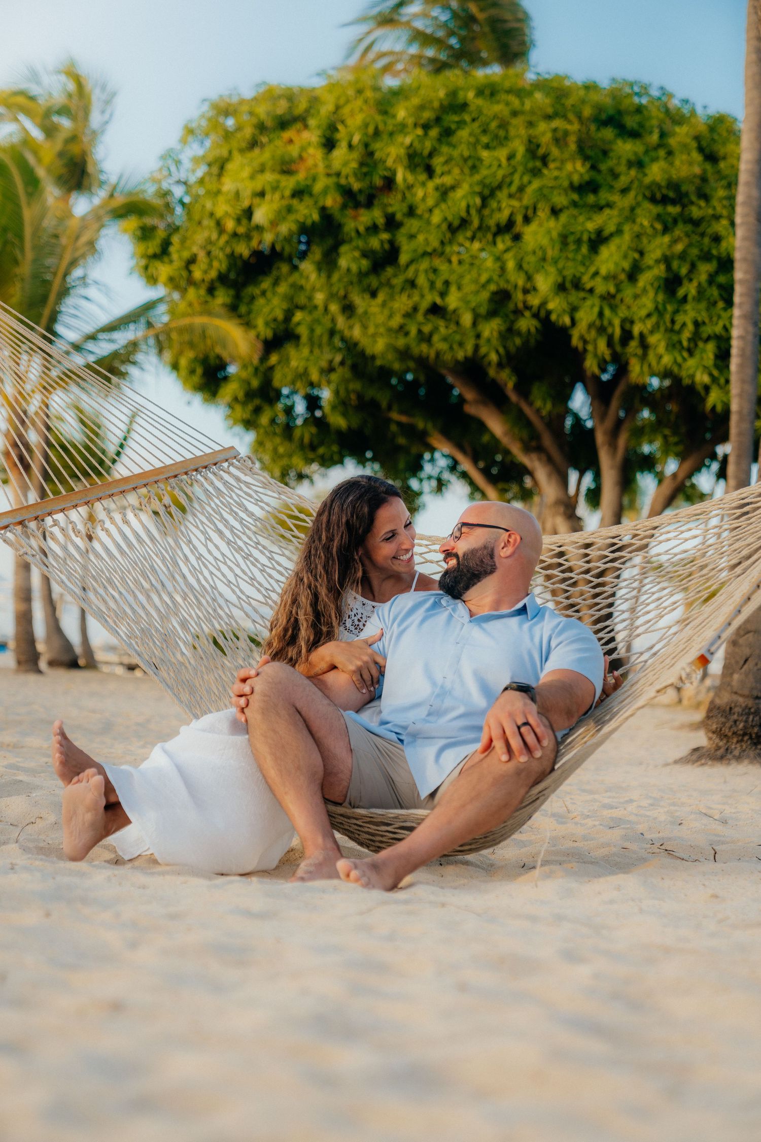 Relaxed beach photos of people lounging in hammocks on a tropical shore.