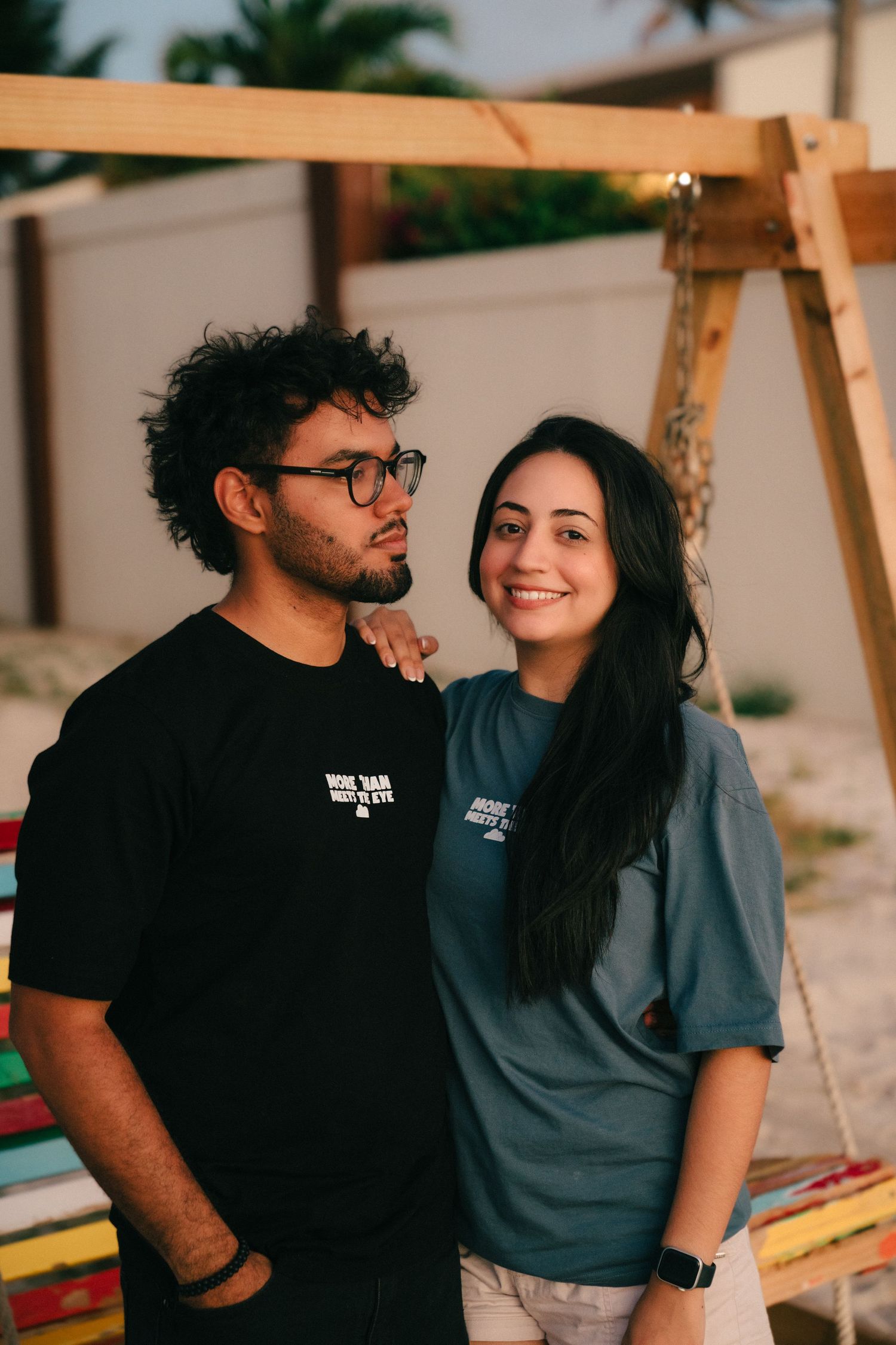 A couple in casual attire sharing intimate moments together in a warm-toned setting.