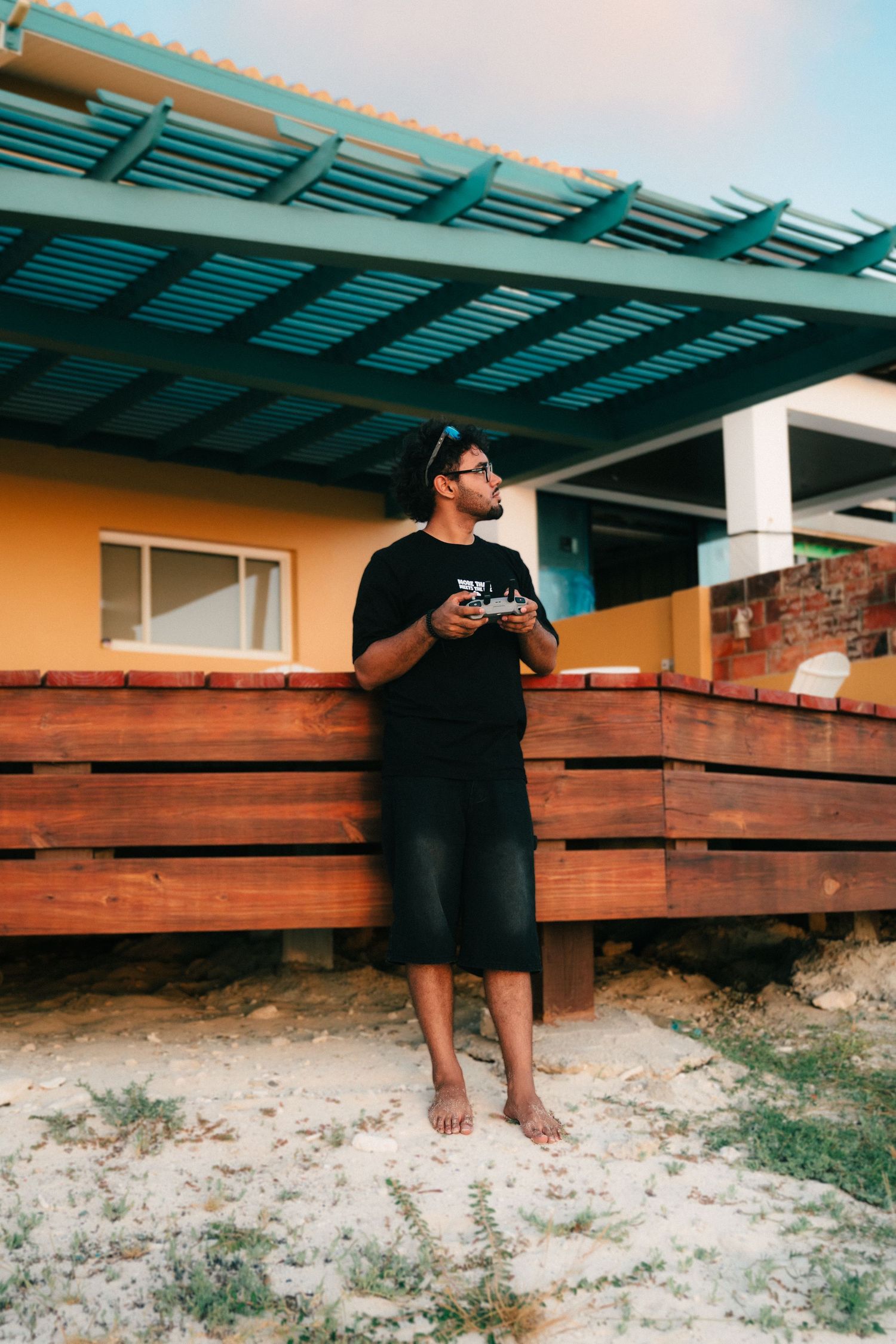 A series of panoramic photos showing someone in black sitting on a wooden deck against a turquoise-roofed structure.