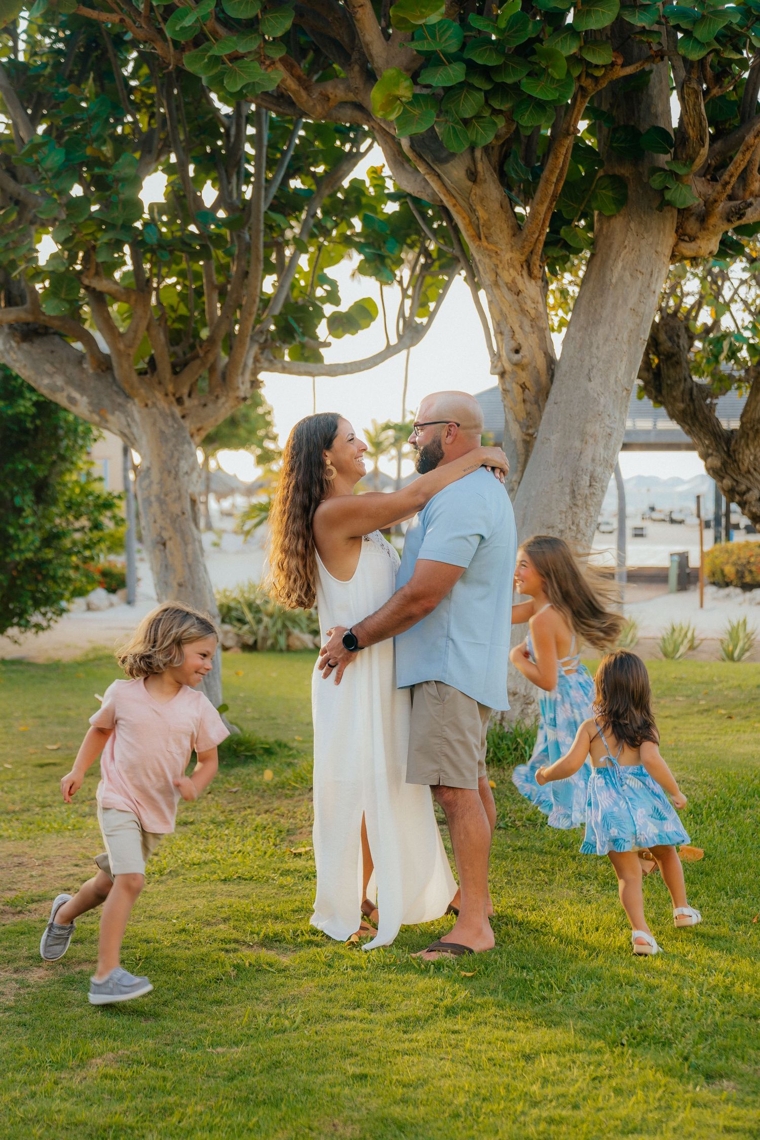 Playful moments captured under green trees on a sunny lawn.