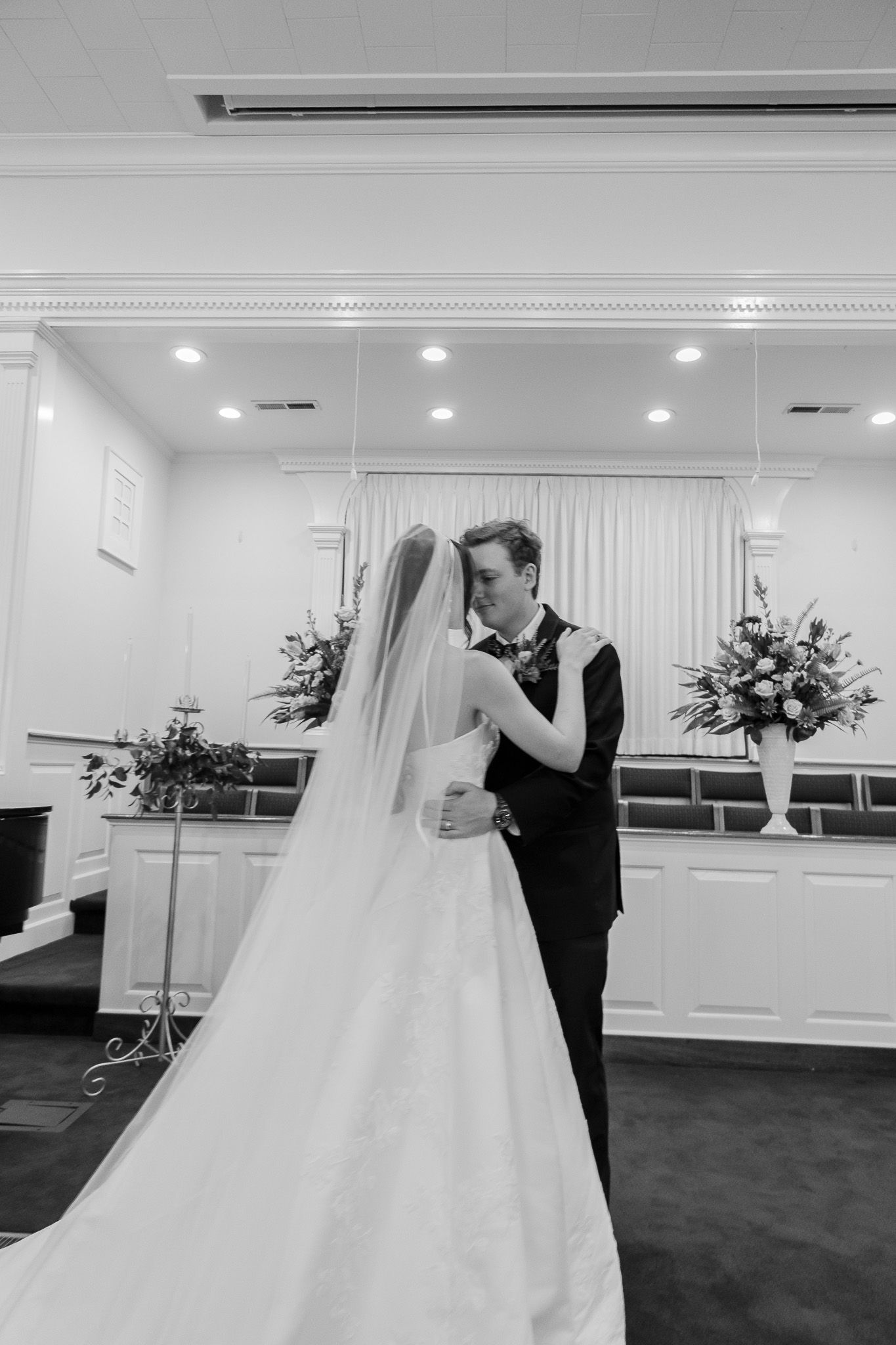 Black and white photo of a bride and groom sharing their first dance in a elegant church chapel.