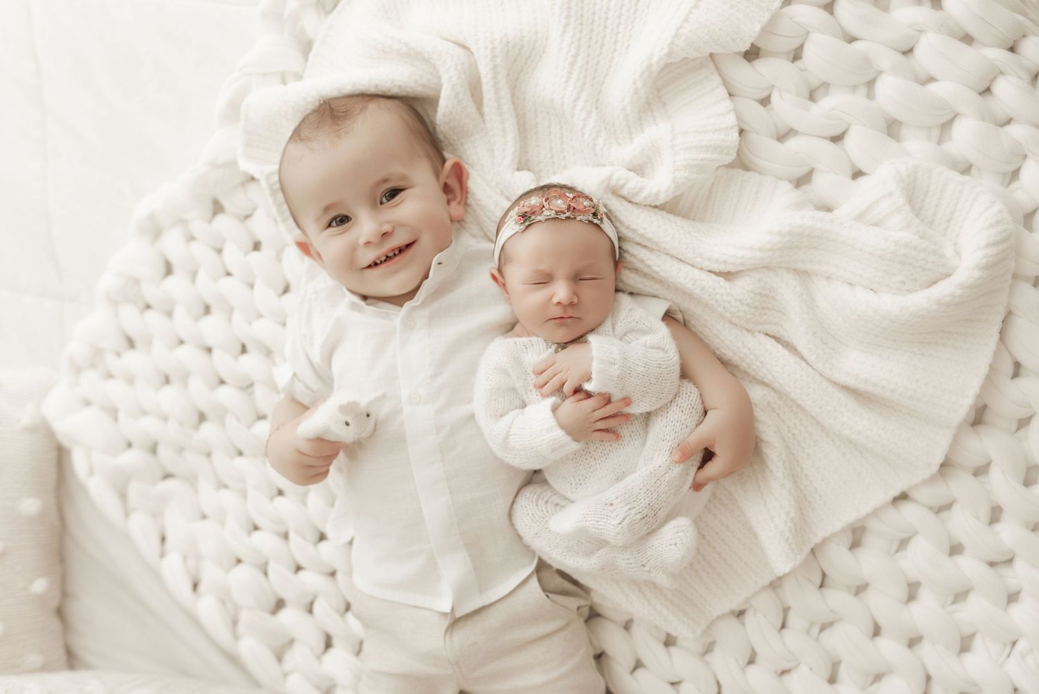 Baby wearing white clothing lies on textured cream knit blanket in series of connected photos.