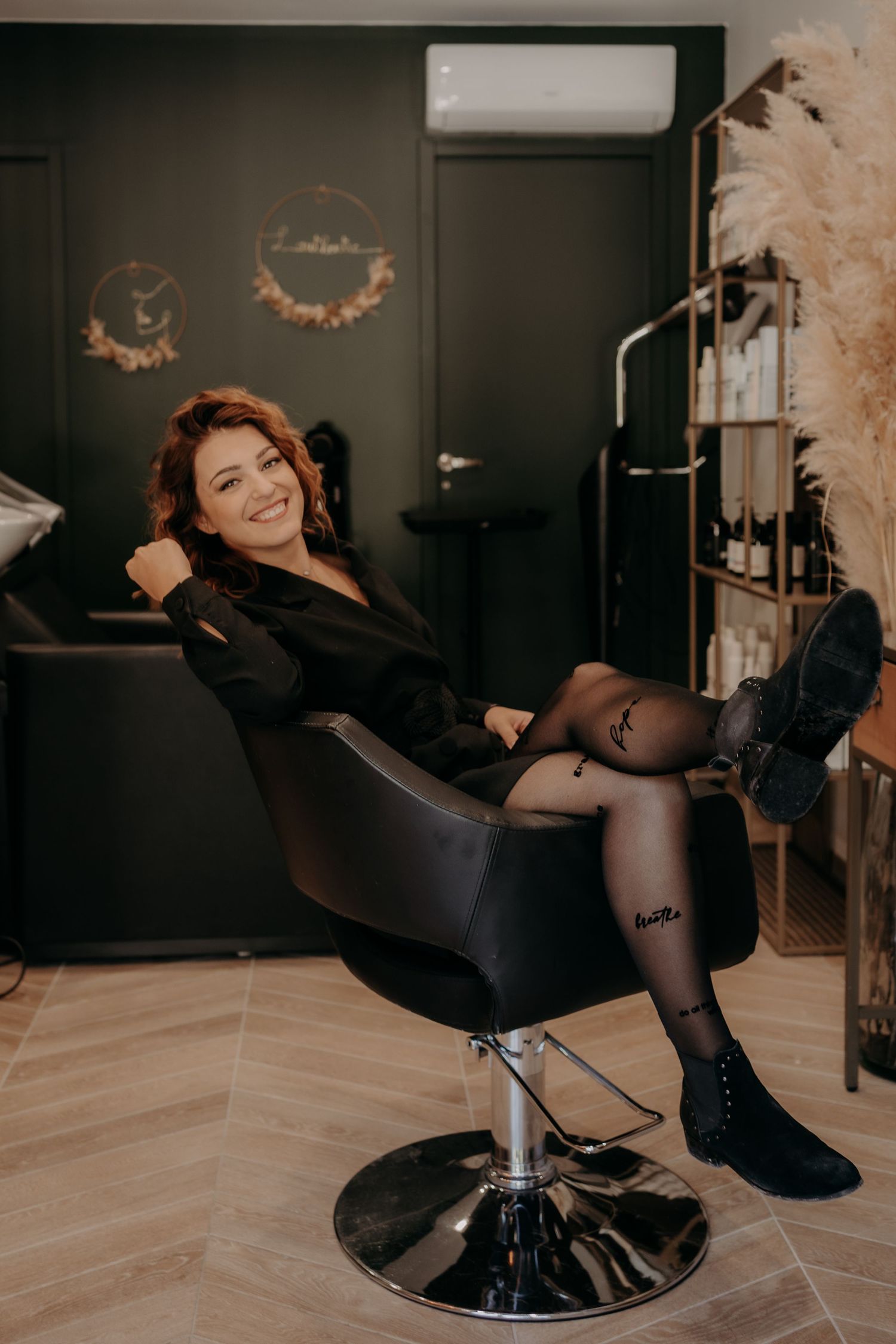 Stylish salon chair photography session with decorative elements in dark room setting.