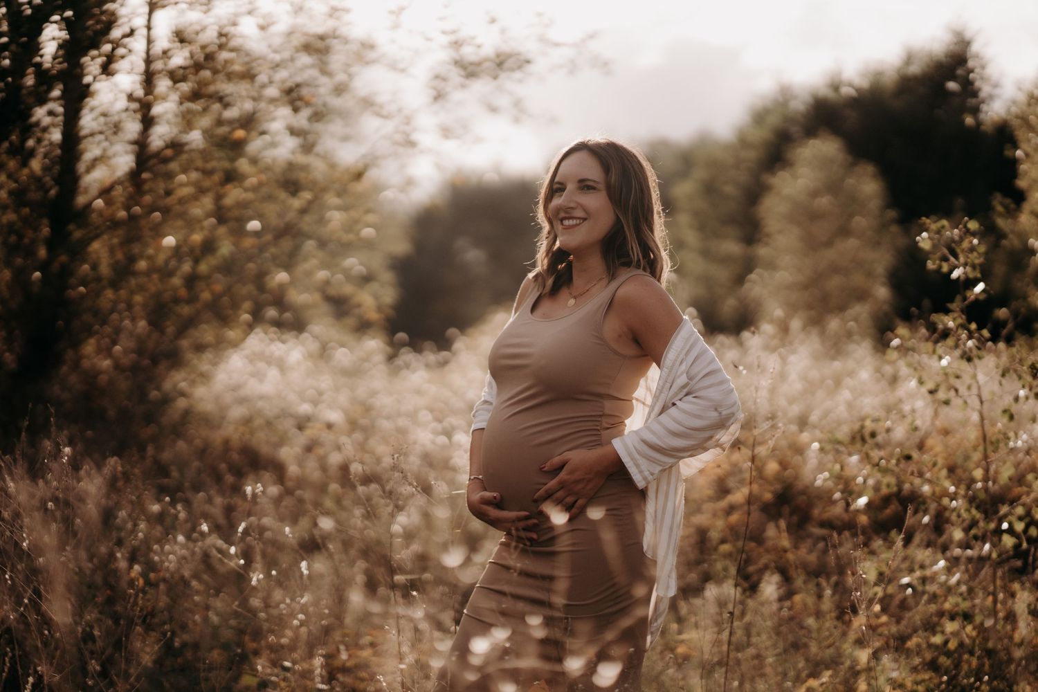 Series of maternity photos showing a woman in a brown dress at sunset in a field.