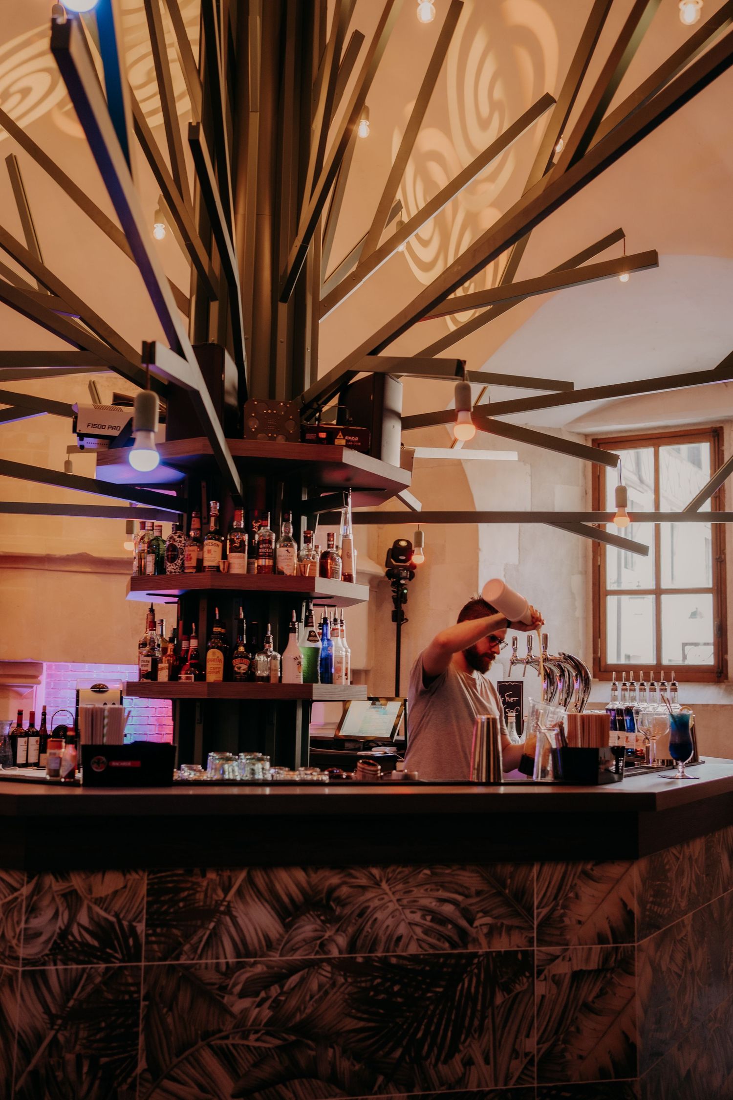 Stylish bar interior with exposed wooden beams and ambient lighting.