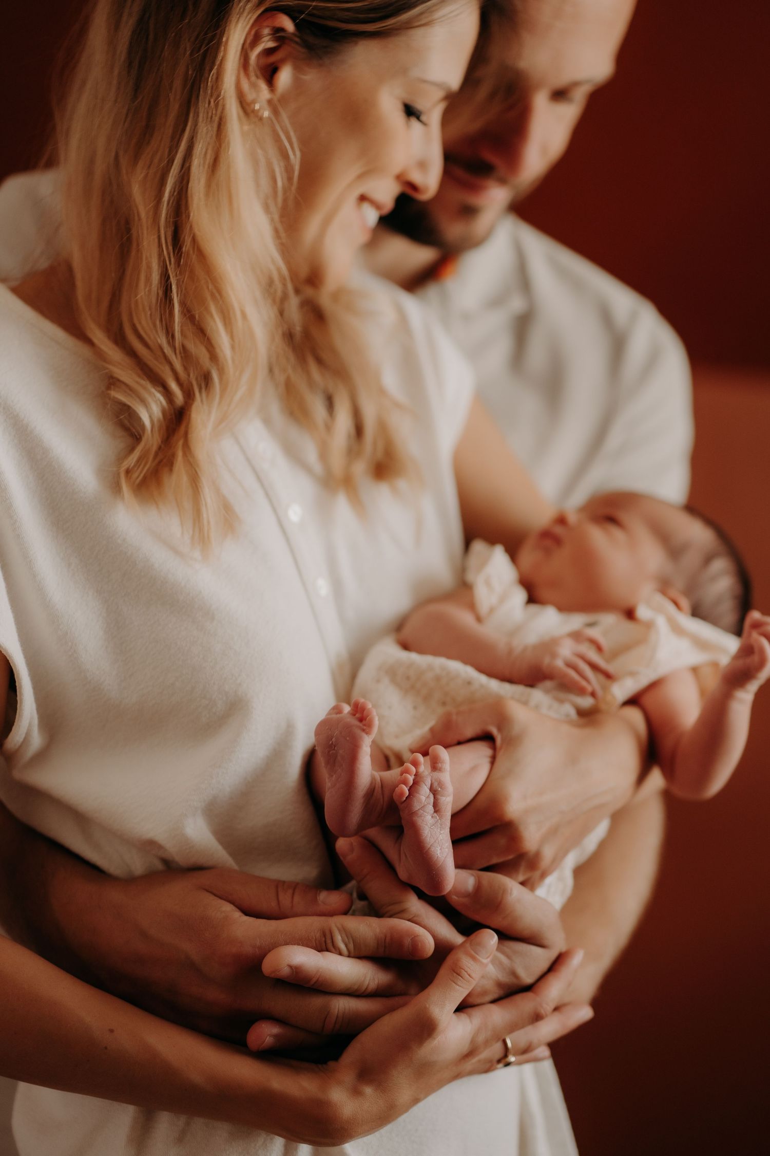 Gentle newborn photography session in warm, moody lighting.