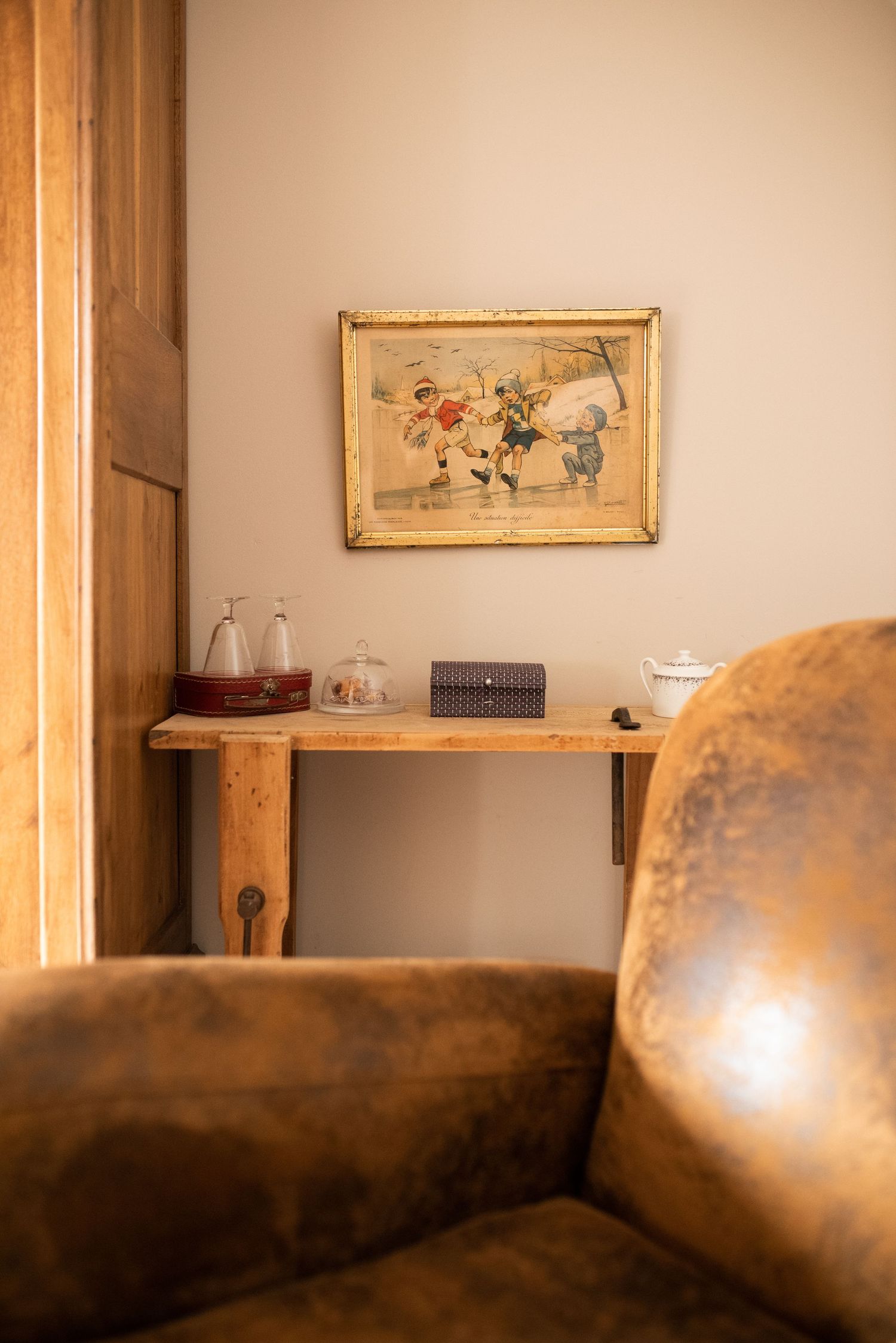 Warm-toned interior room with leather seating and framed artwork on beige walls.