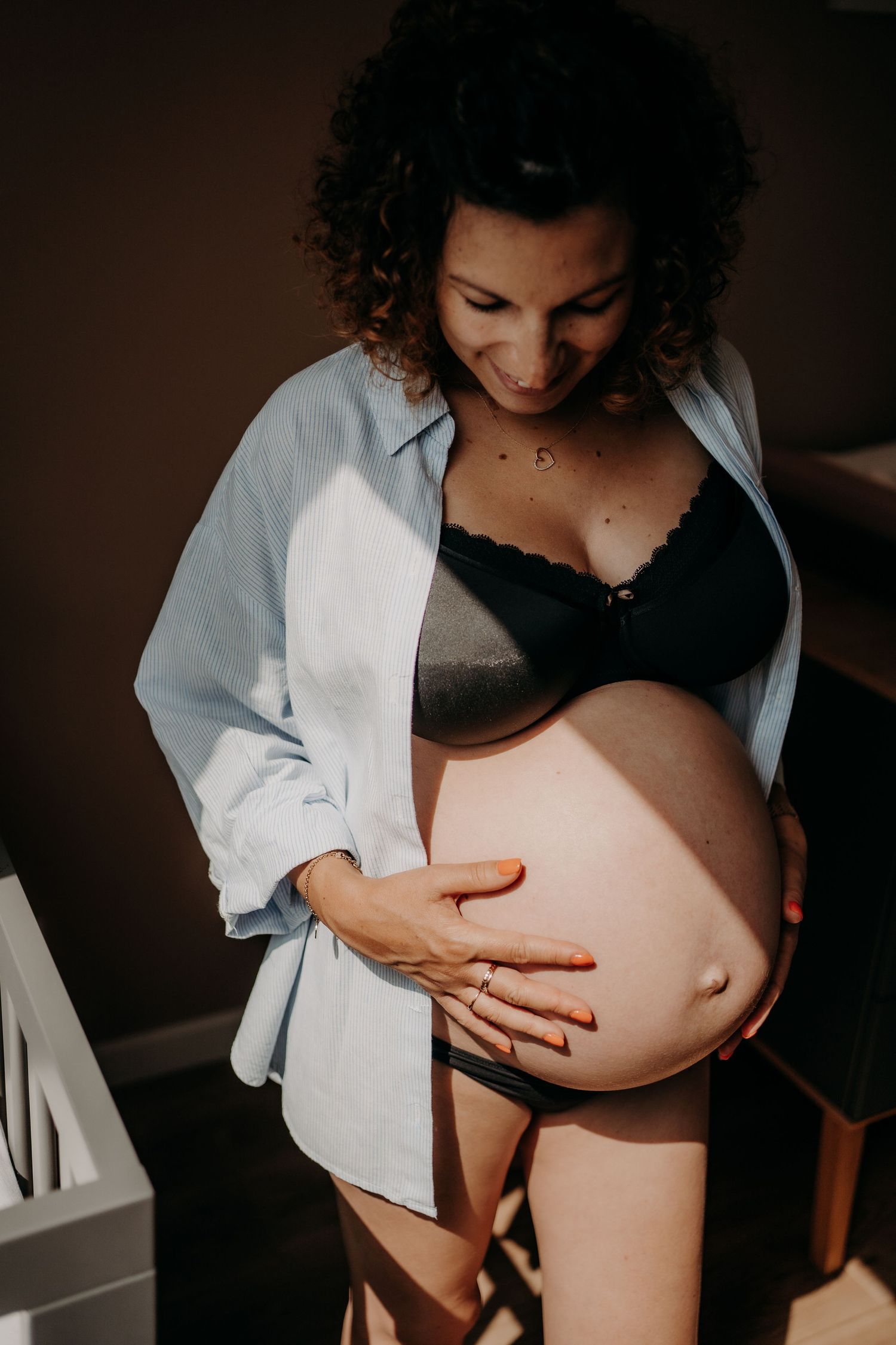 Artistic maternity photos showing a pregnant belly in dramatic lighting.