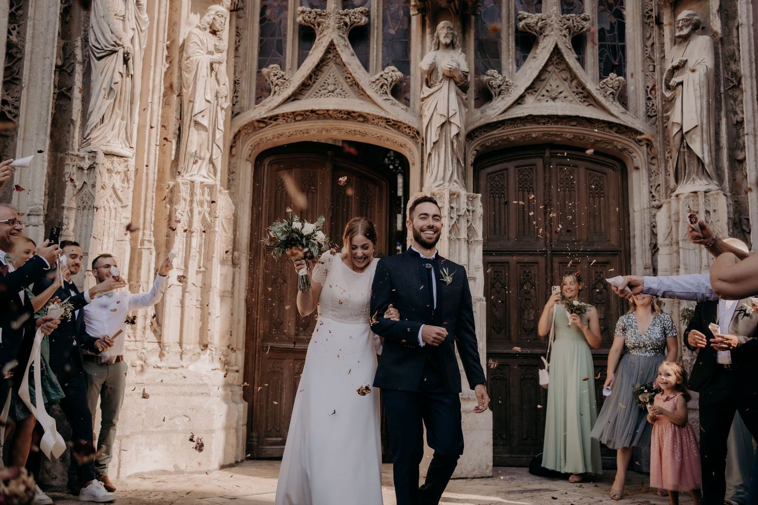 Wedding ceremony taking place at a grand gothic cathedral with ornate stone architecture.