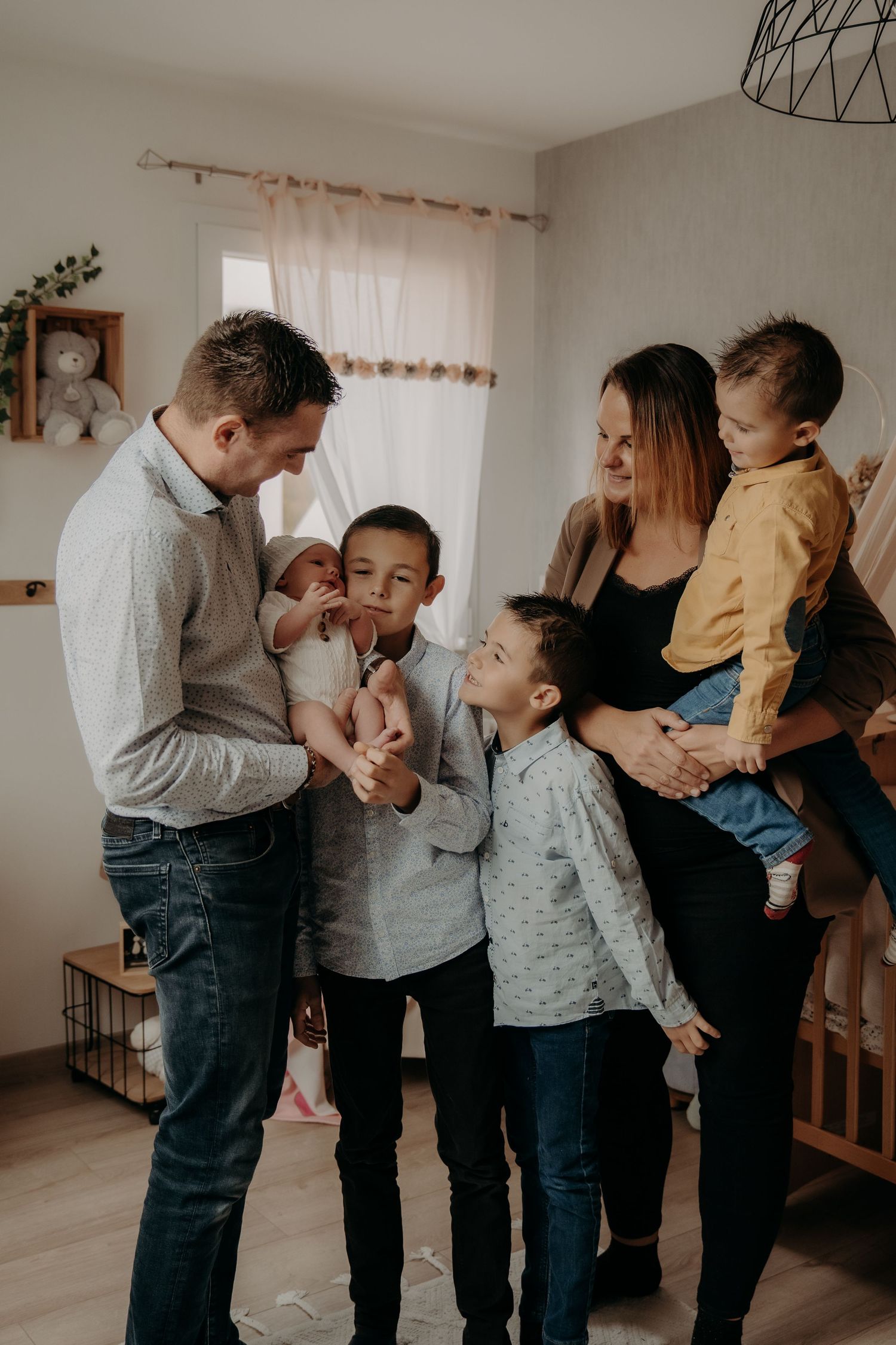 A heartwarming indoor family moment showing playful interaction between parents and children in a cozy living room.