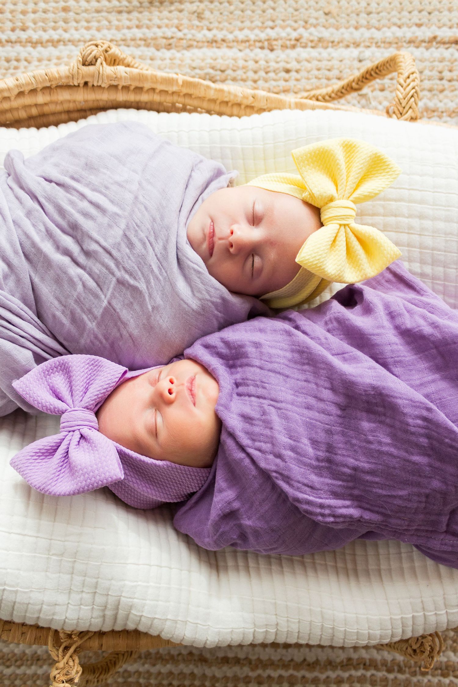 Newborn twins swaddled in a basket.