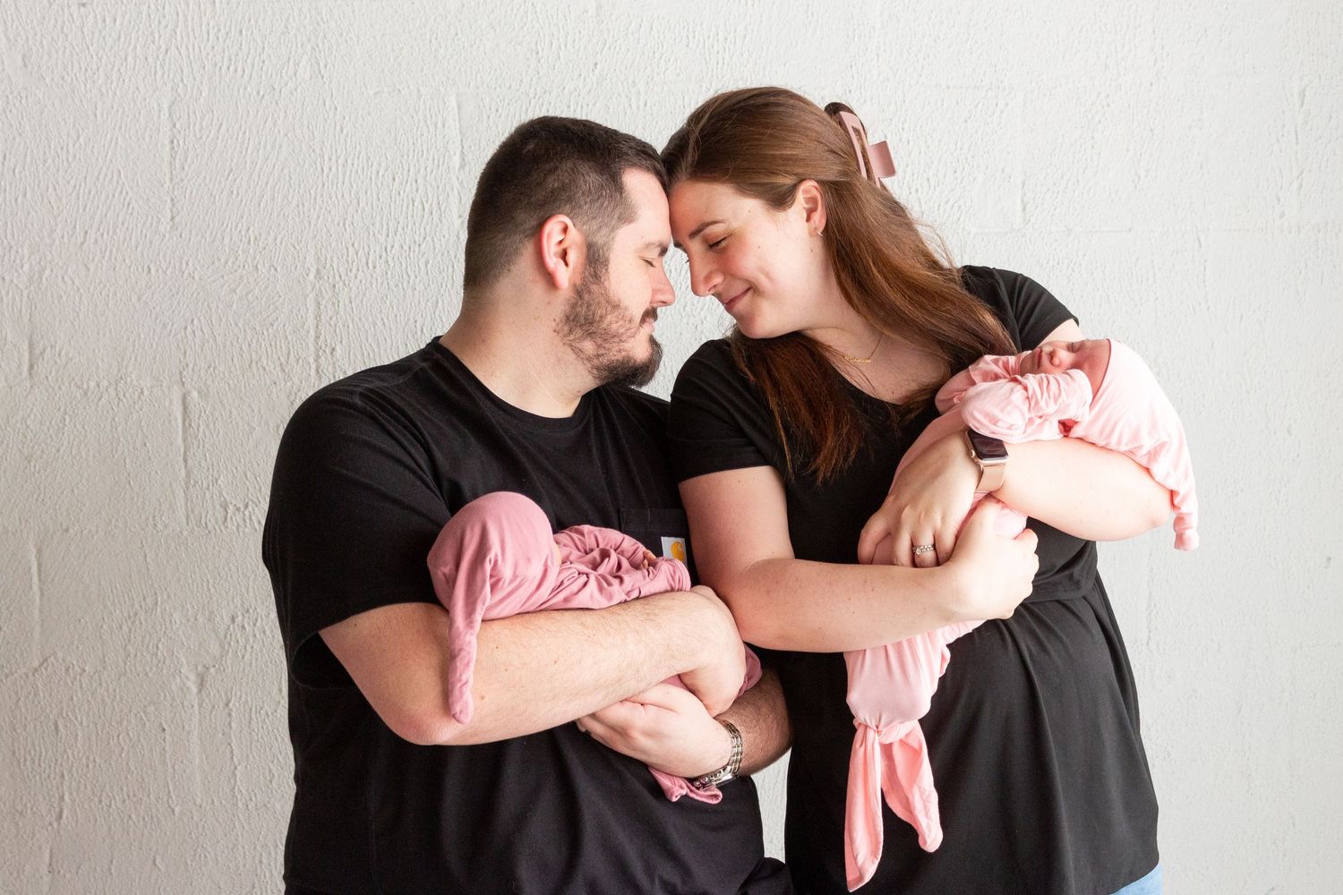 Couple holding newborn twins.