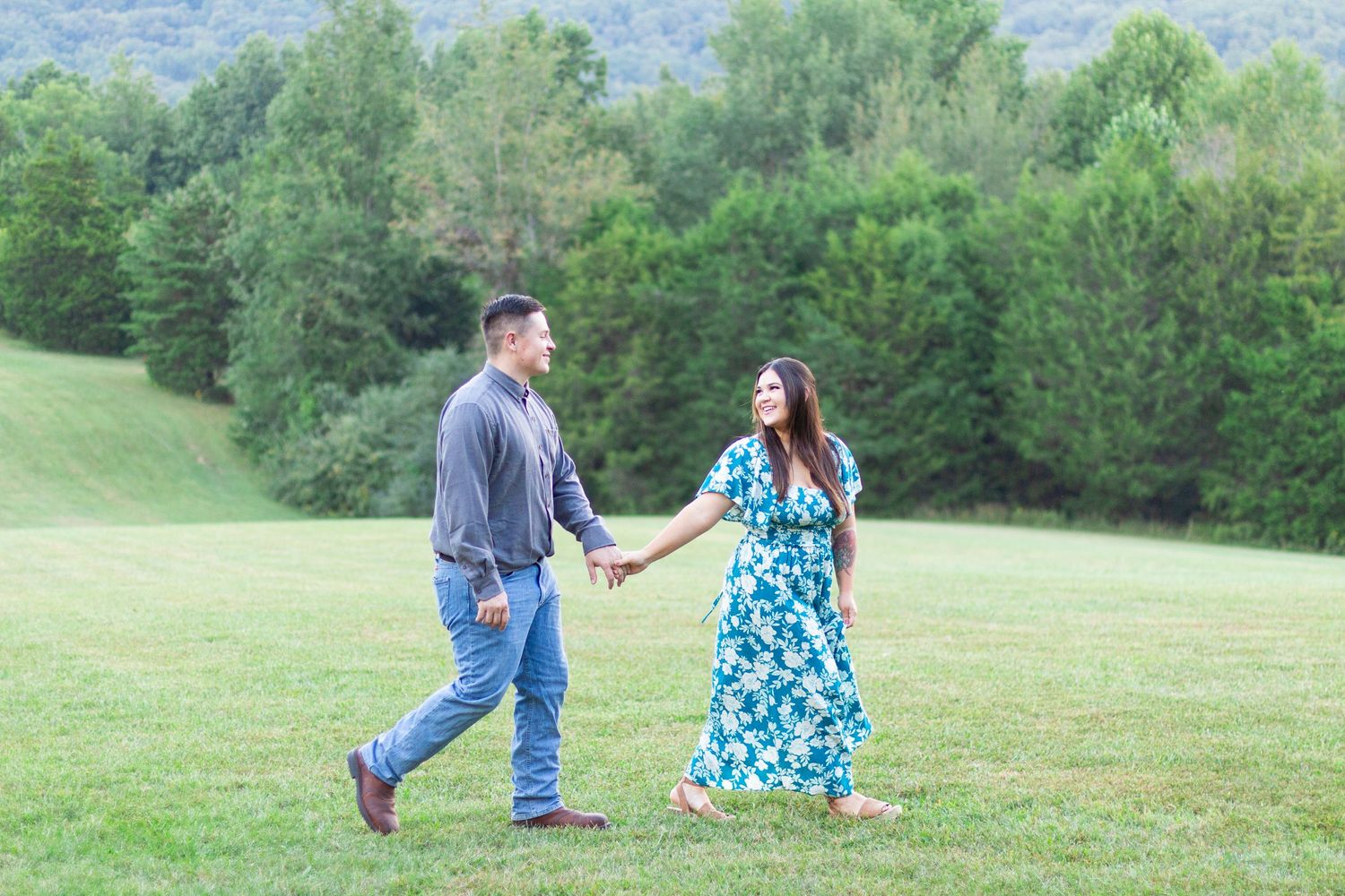 Couple holding hands and walking in a field
