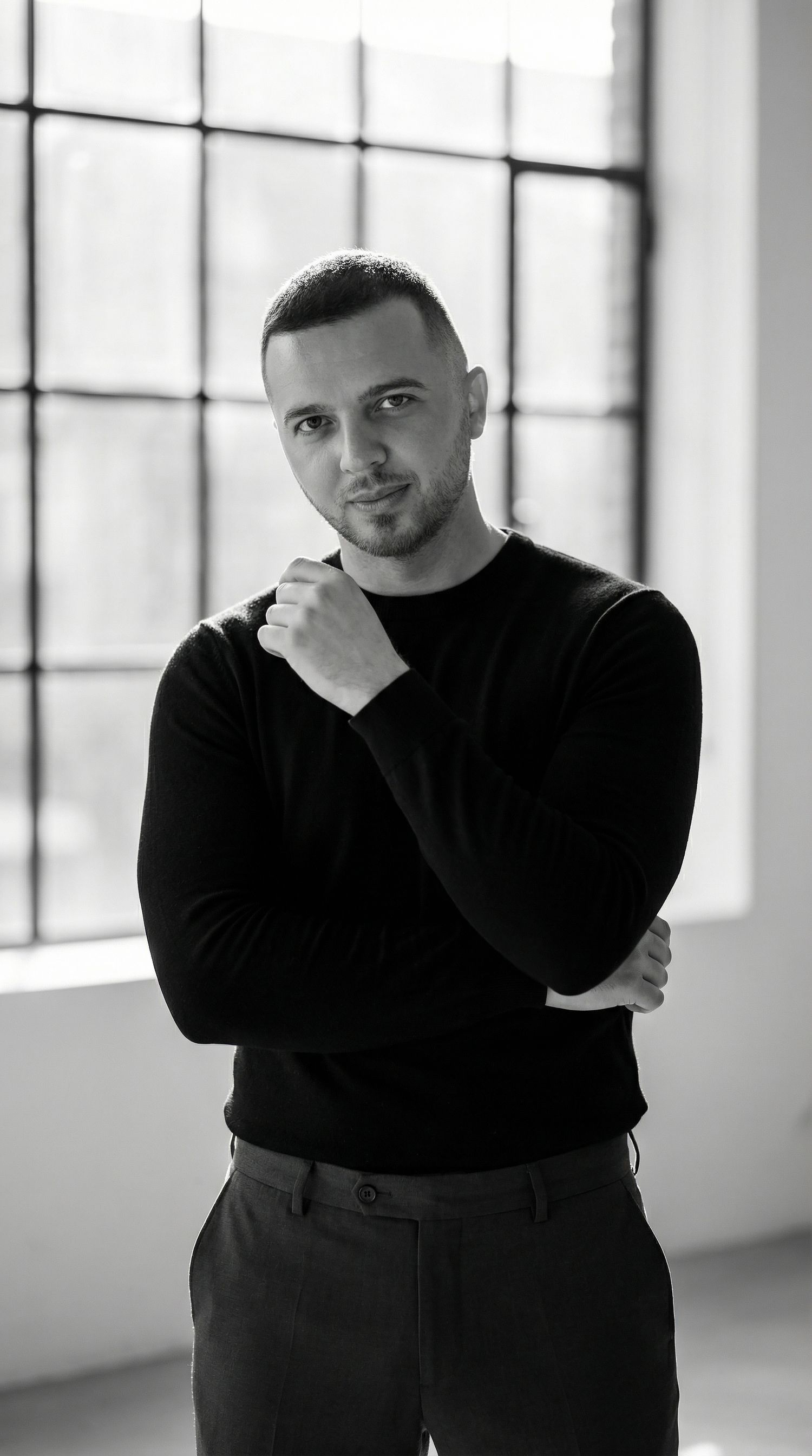 Black and white portrait series showing artistic poses against a bright window backdrop.