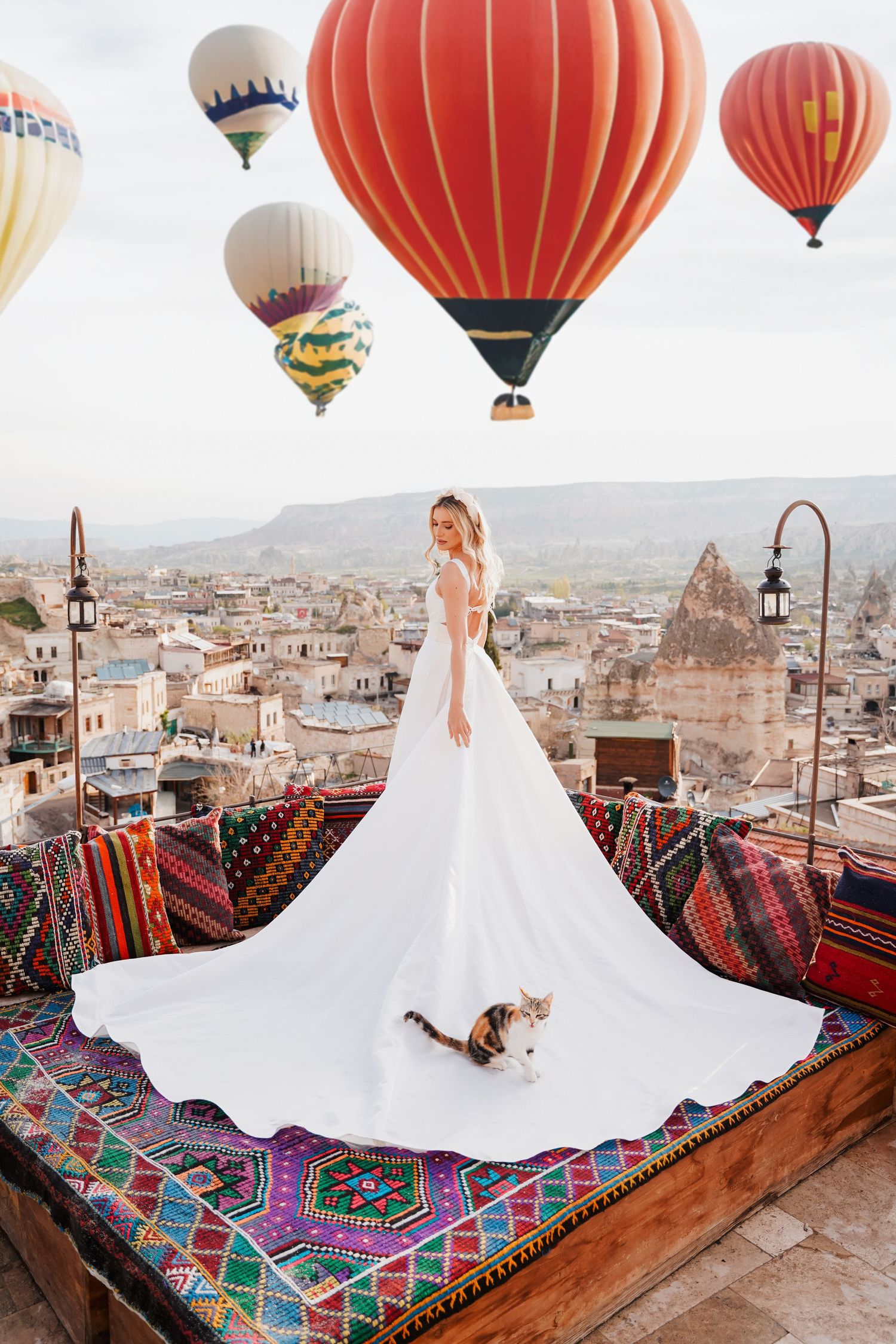 Stunning wedding dress photos with colorful hot air balloons floating over a cityscape backdrop.