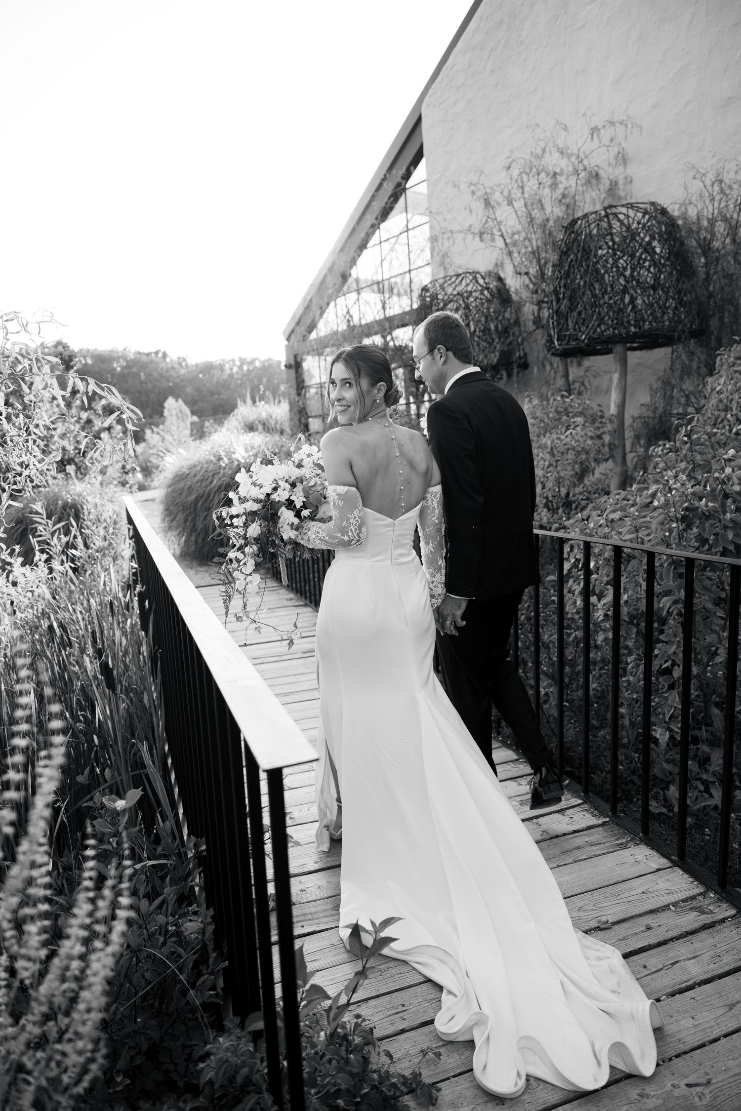 Black and white wedding photos of couple on rustic wooden deck with scenic backdrop.