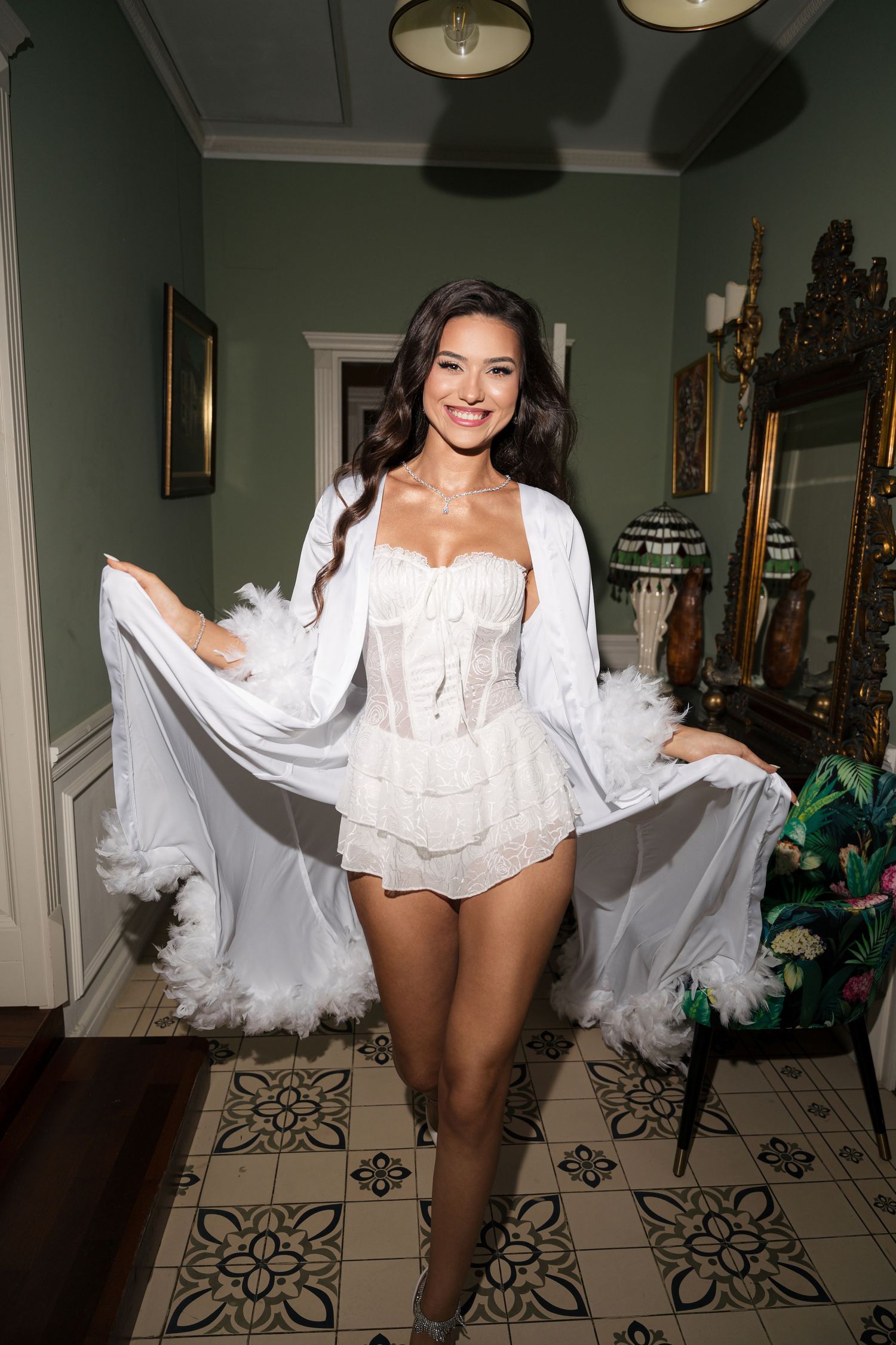 A white lace bridal lingerie ensemble with flowing sheer robe photographed in an elegant interior setting.