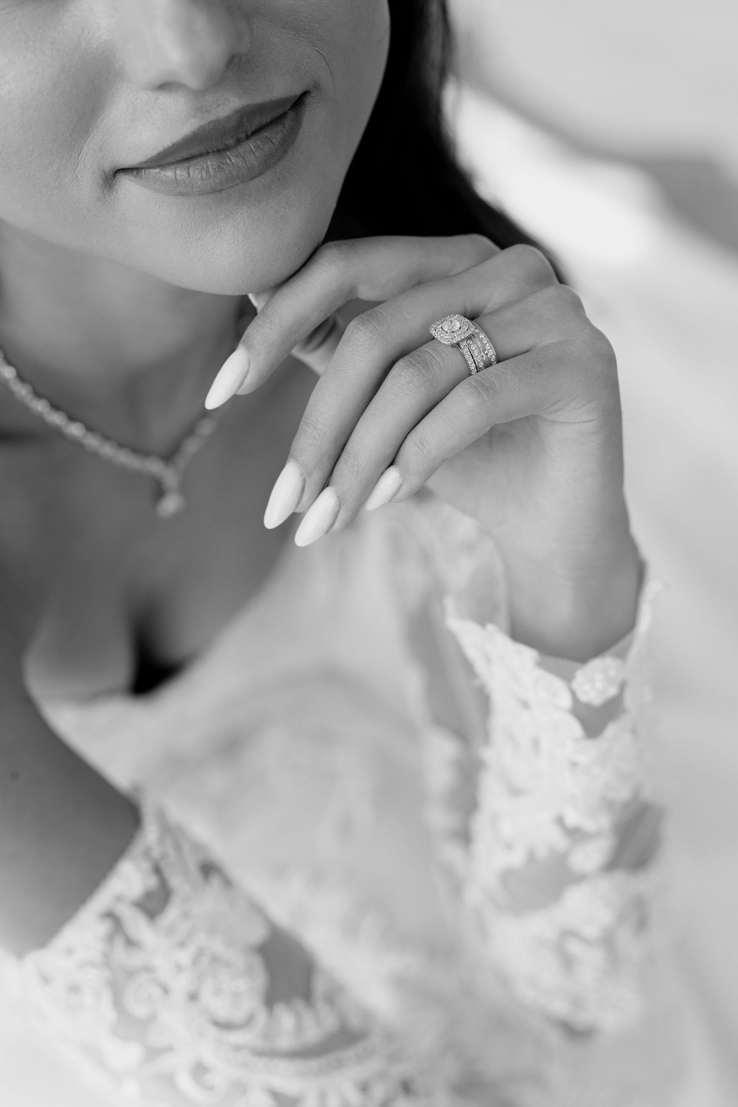 Black and white wedding photography showing a bride's profile and lace details in a romantic artistic style.