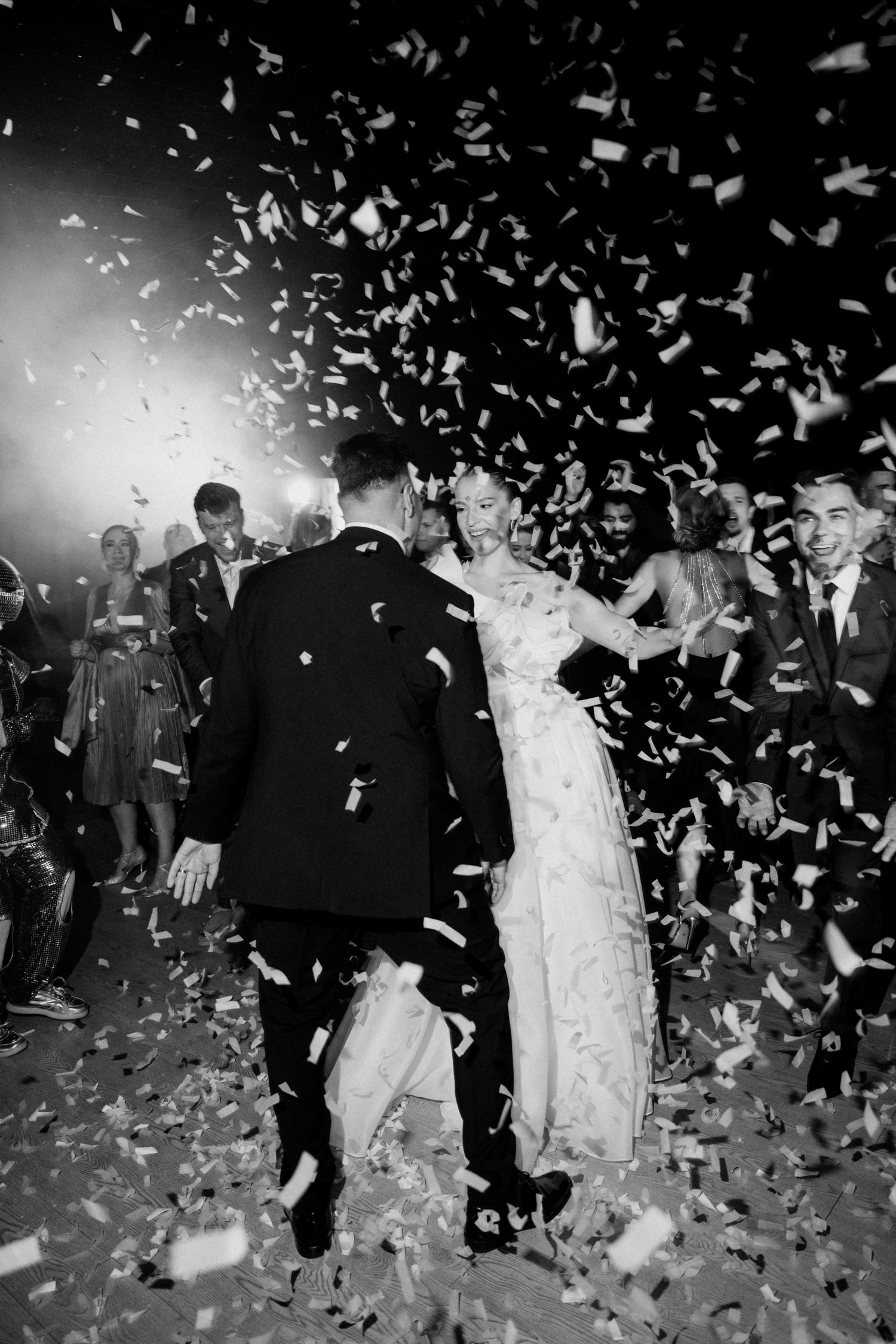 Black and white reception exit with confetti shower creating magical atmosphere.