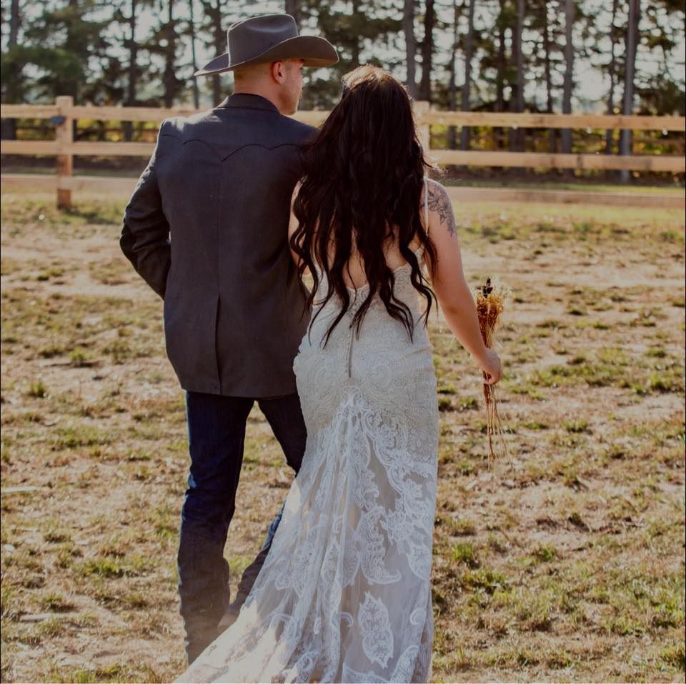 Couple walking hand in hand after their ceremony surrounded by family and friends.
