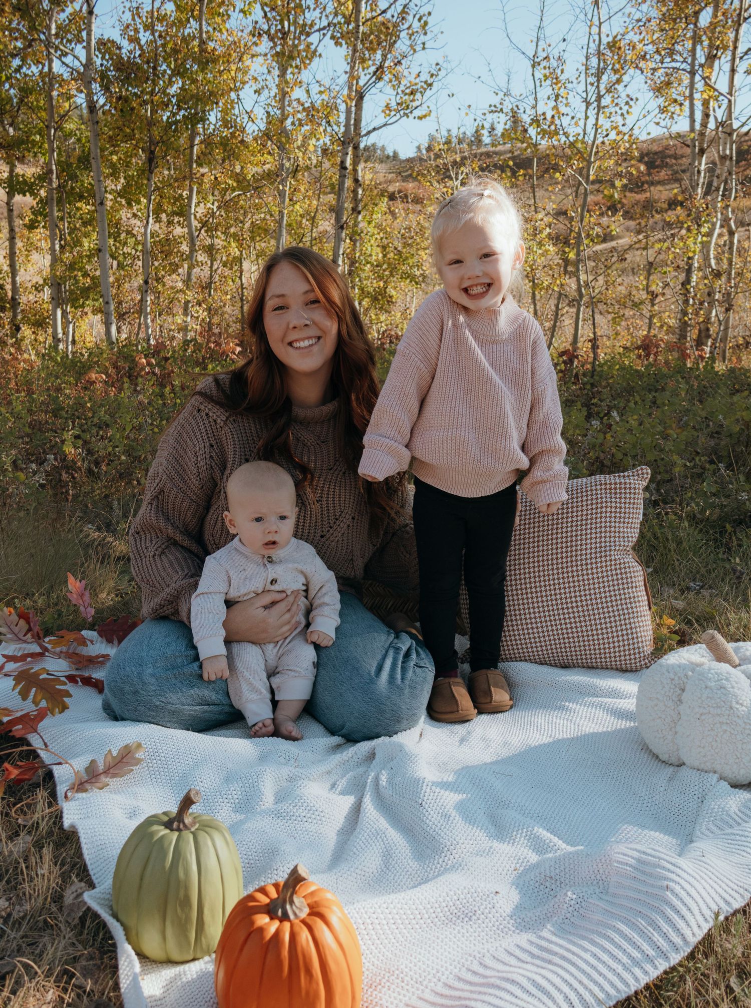 A mom sitting on a blanket with her babies during a mommy and me session in Havre Montana